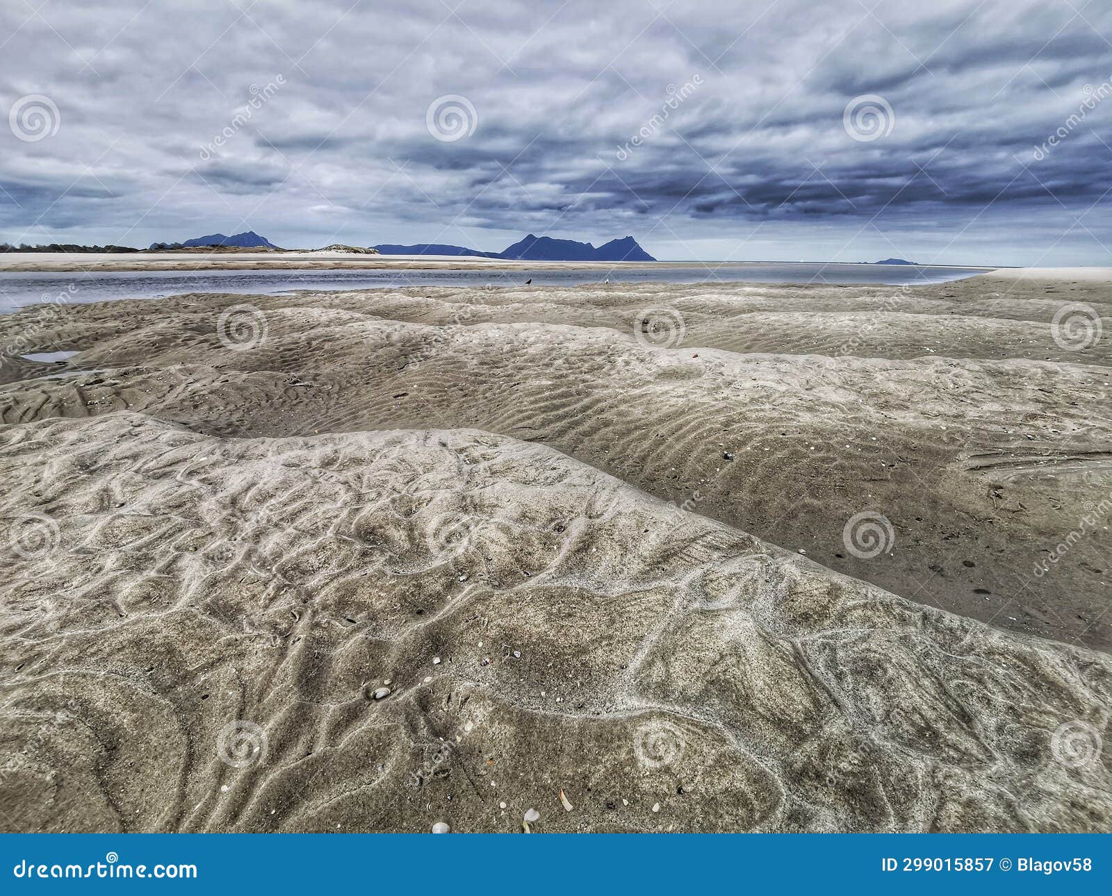 sand beach patterns on an ocean beach shore in the south pacific under cloudy sky
