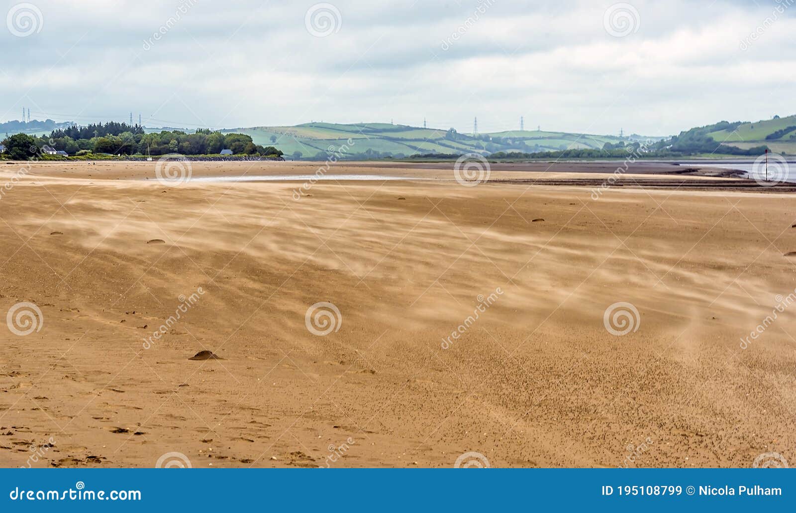 sand blowing across the beach at the village of llansteffan, wales