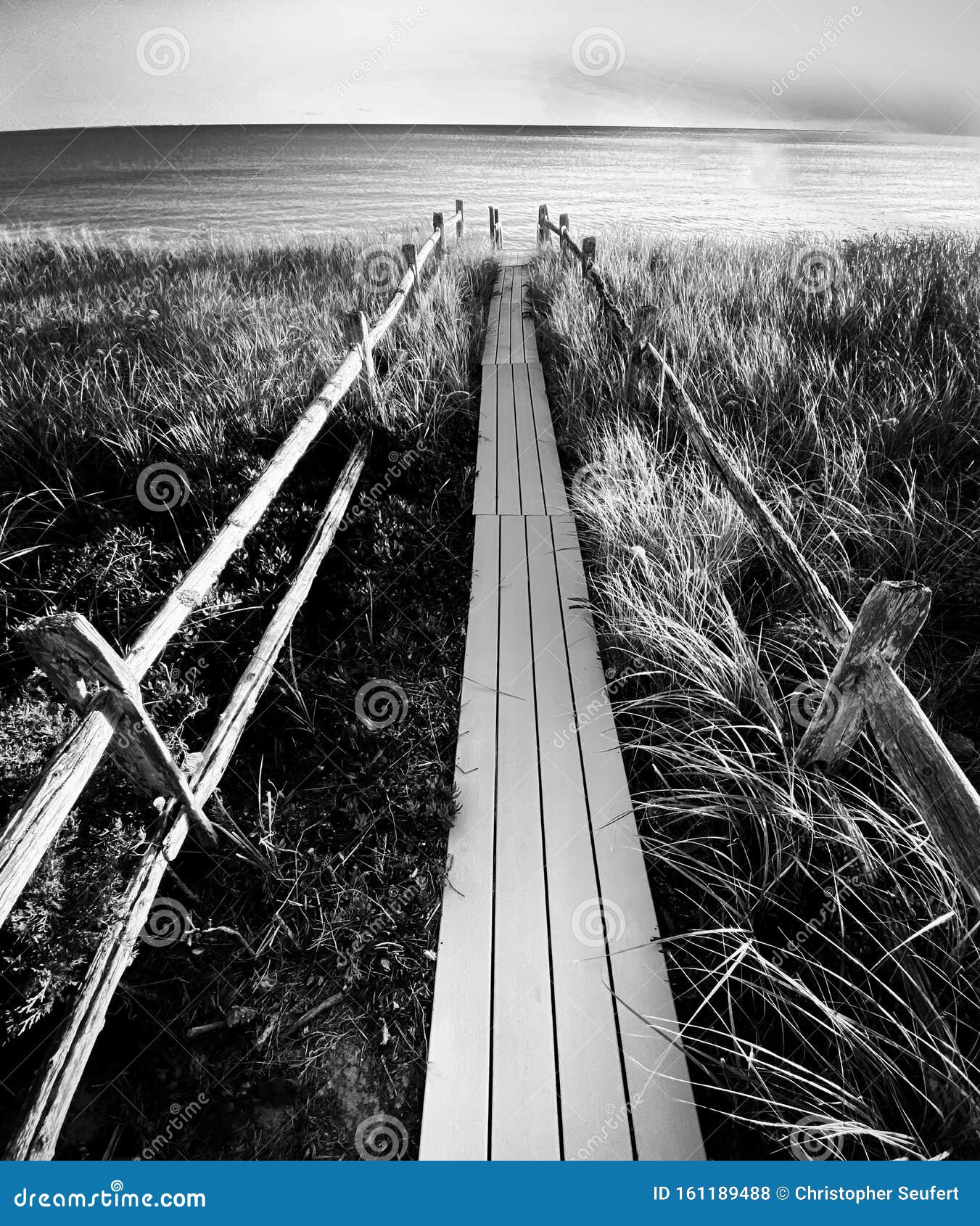 A Sand Bluff and Cloudy Sky Frame a Cape Cod Ocean. Stock Photo Image