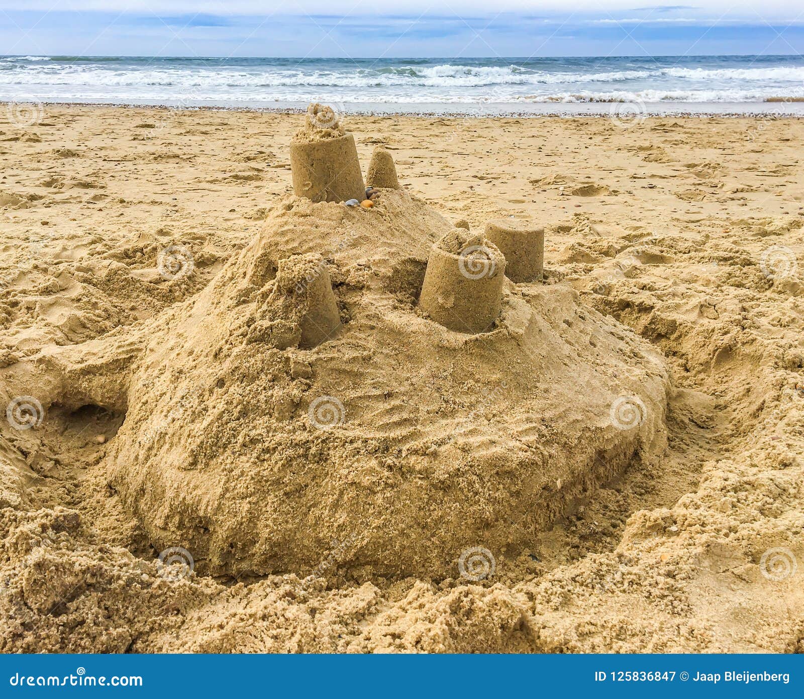 sand castle building with towers on the beach with view on the sea