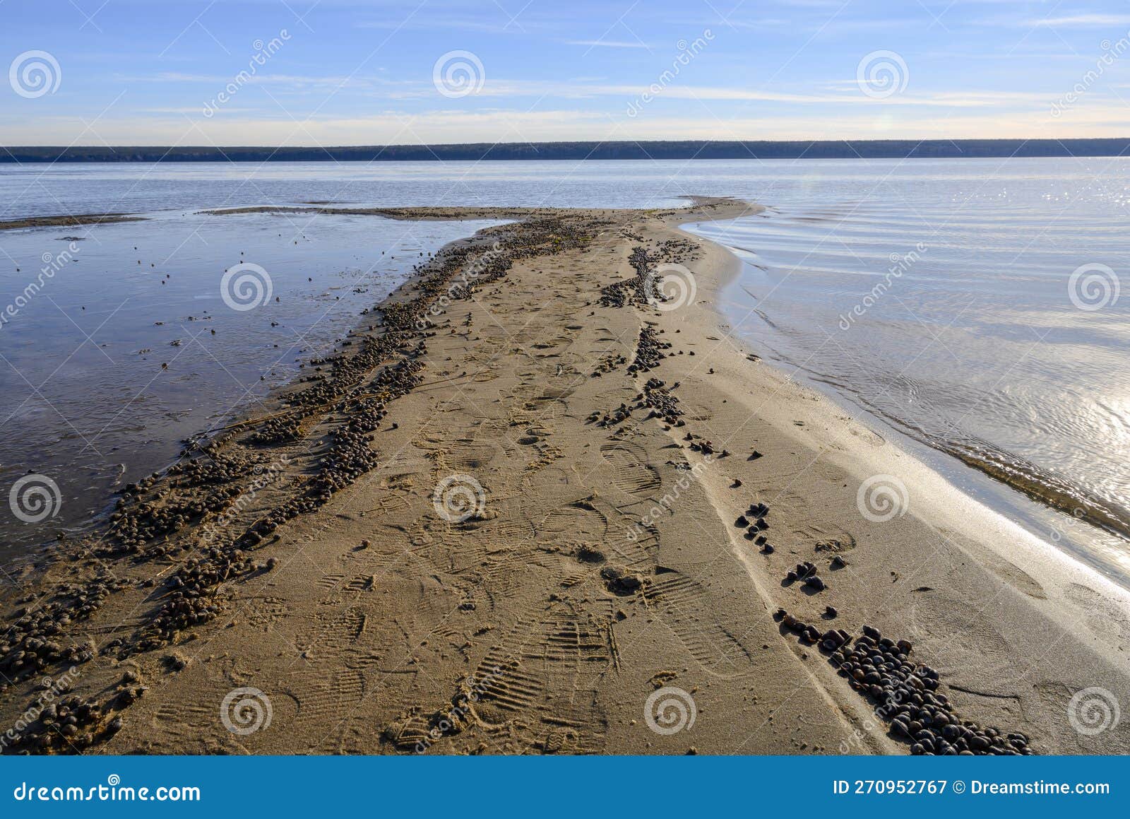 A Sand Spit Going into the River, with Traces of People and a Huge
