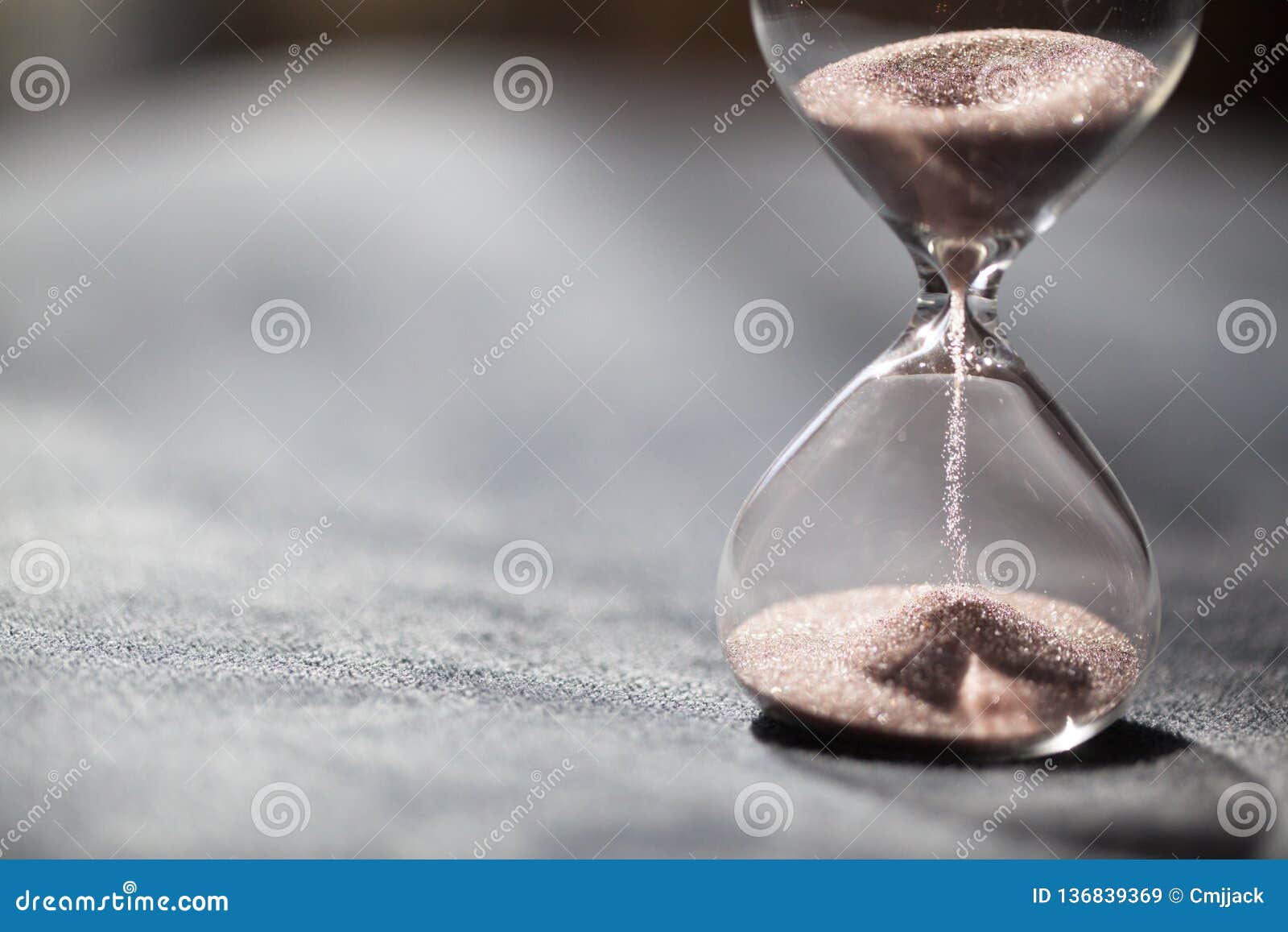 a sandglass, modern hourglass or egg timer with shadow showing the last second or last minute or time out.