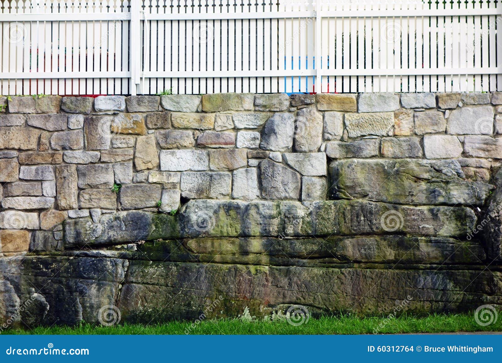 sandstone wall and white picket fence