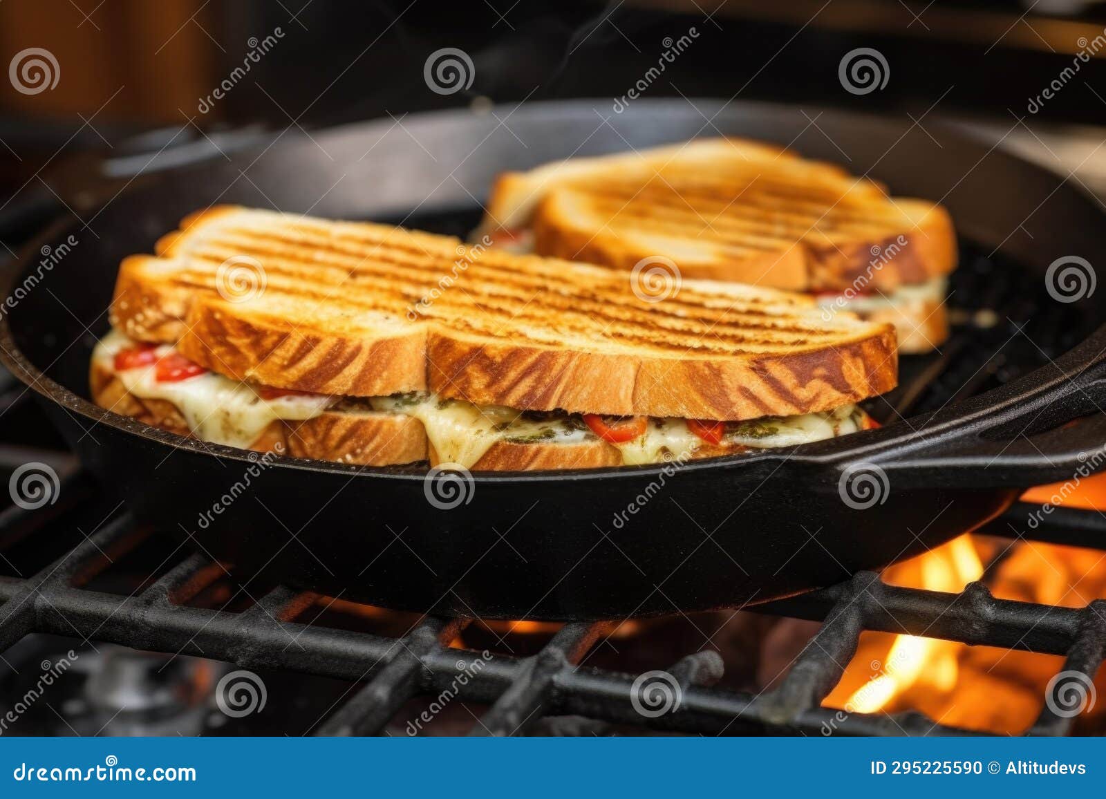 Sandwich with Grill Marks Under Cast Iron Press on Stovetop Stock Photo