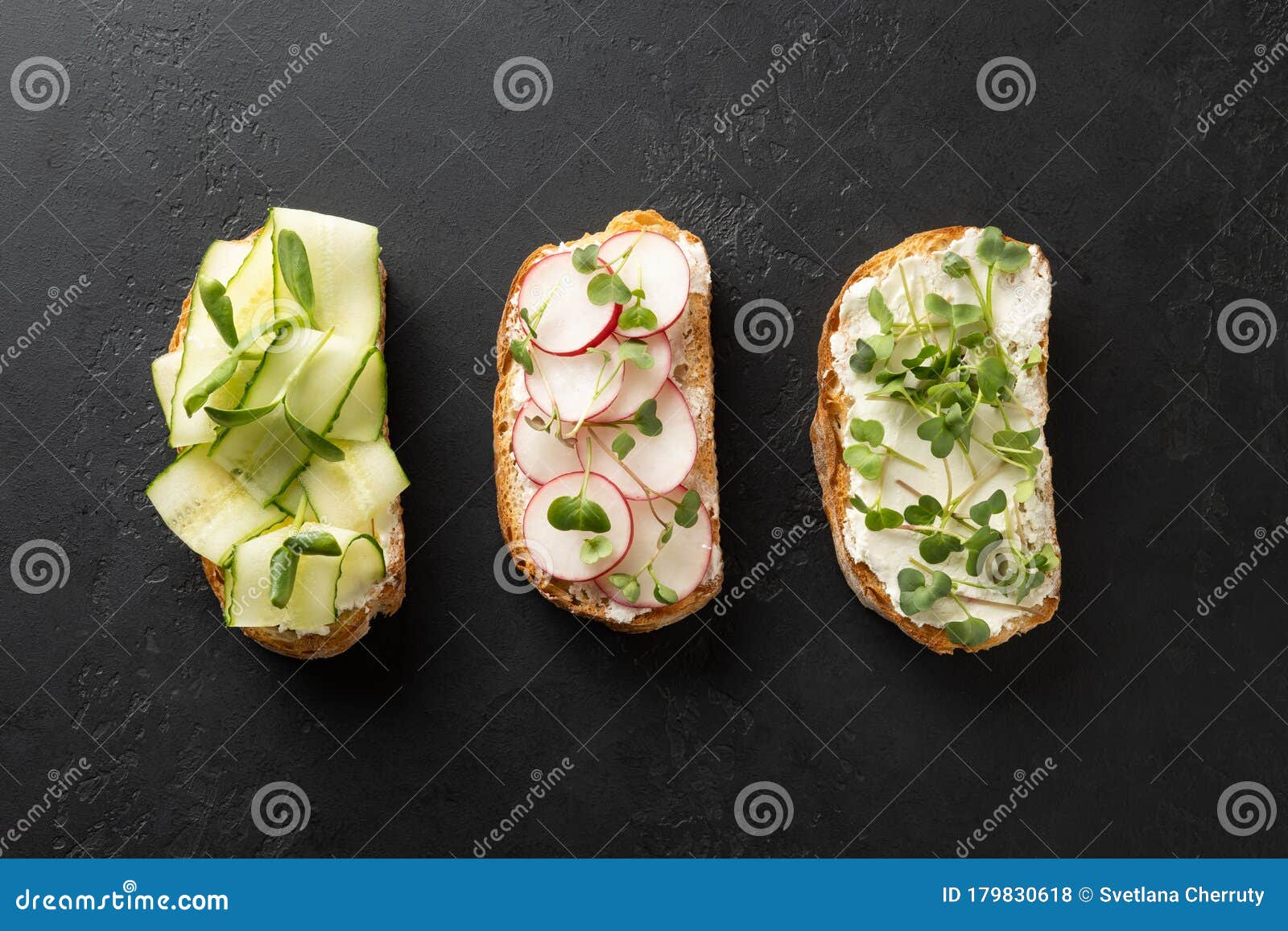 sandwiches with sundries tomatoes, fresh radish, microgreens, cream cheese on black . top view