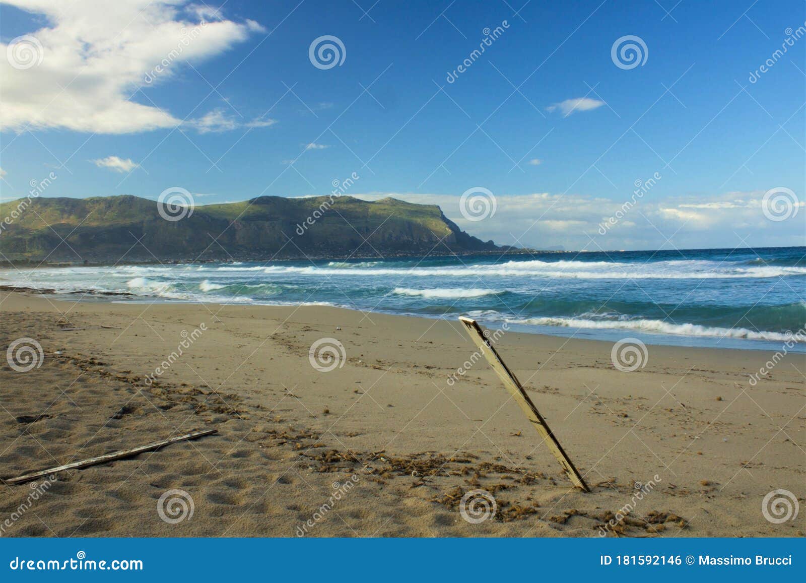 Sandy Beach with Rough Sea Headland in the Background and Clouds Stock