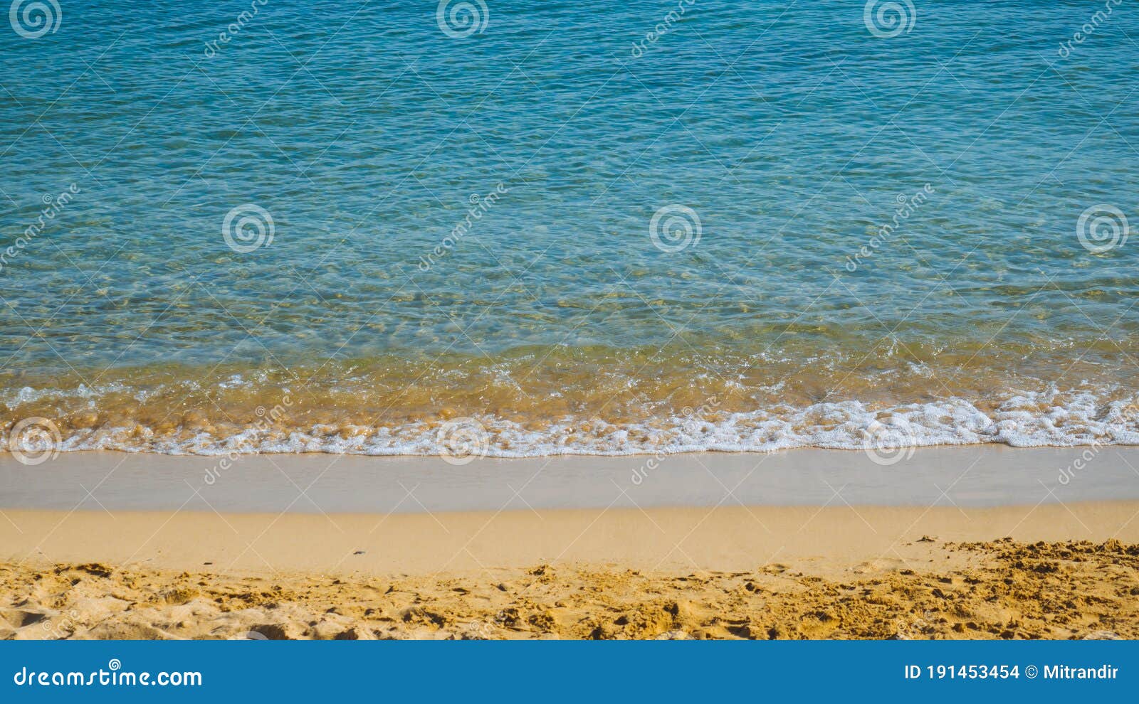 Sandy Beach With Small Waves Blue Sea And Yellow Sand Stock Photo