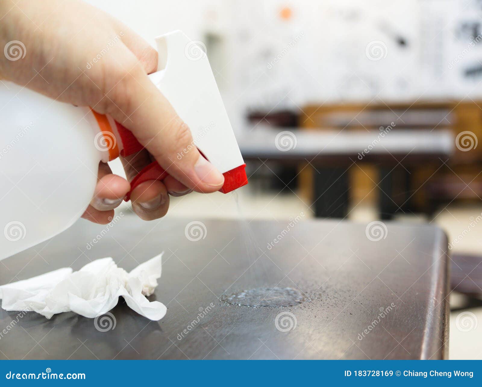 Sanitizing Table with Alcohol Disinfectant Spray Bottle in Restaurant is a Must Stock Image