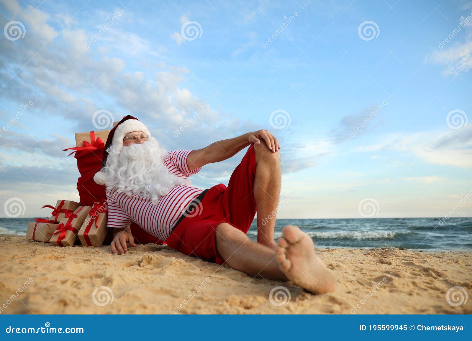 Santa Claus with Bag of Presents Relaxing on Beach, Space for Text ...