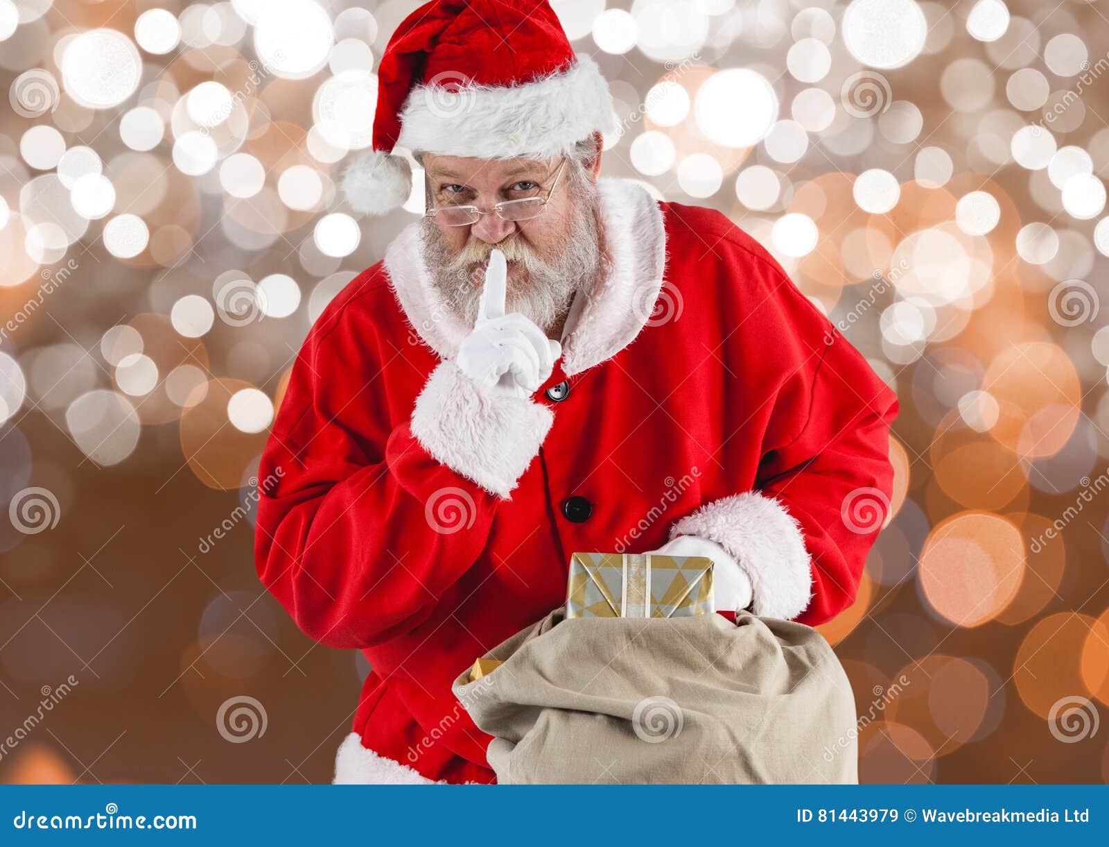 santa claus with finger on lips holding gift bag