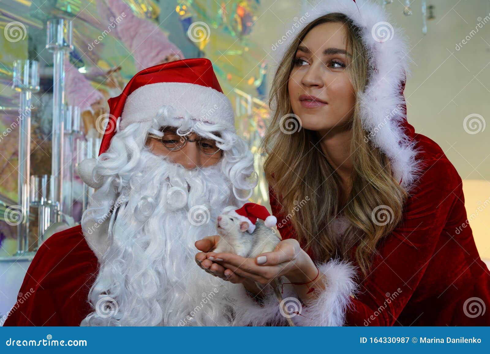 Santa Claus And Santa`s Girlfriend With A Rat In Their Hands Stock