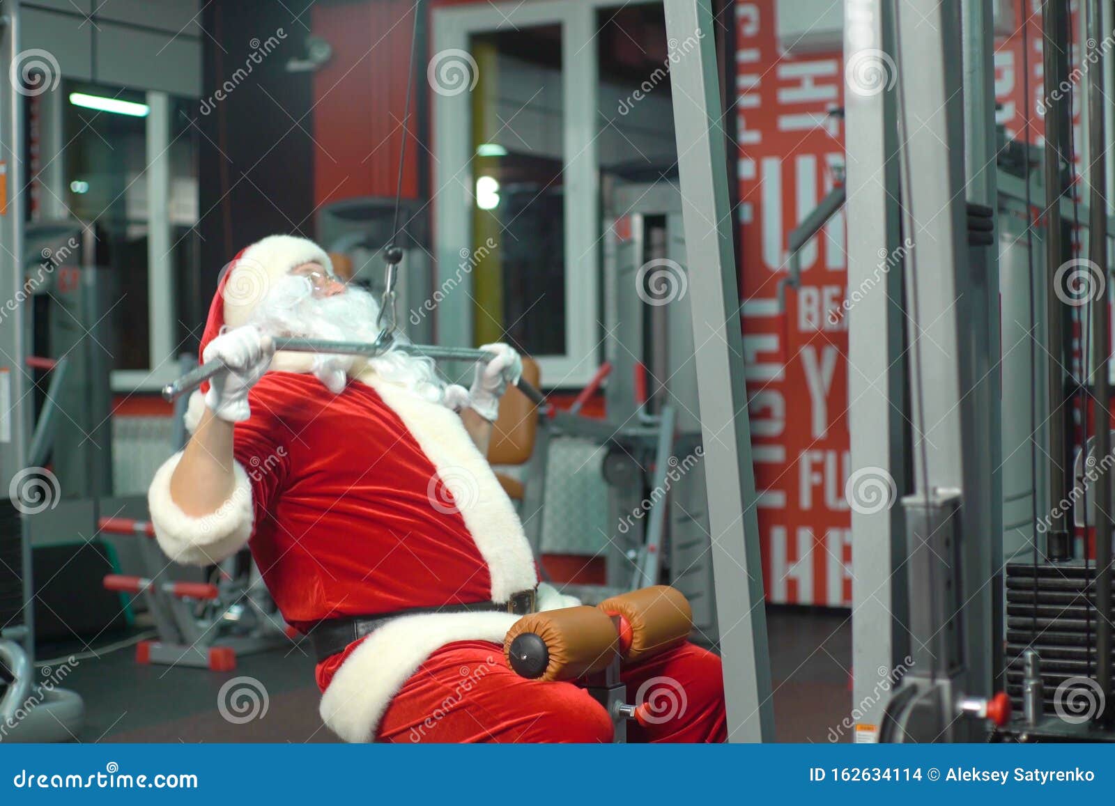 Santa Claus Training at the Gym on Christmas Day. Exercisemachine. Stock Photo Image of