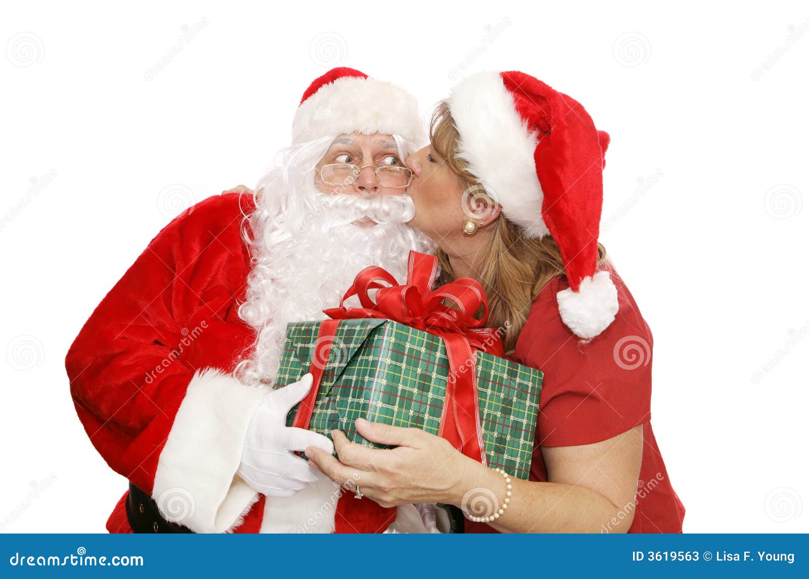 Santas le agradecen besarse. Señora Santa que da a Santa un agradecimiento usted para besarse como él le da un regalo de Navidad. Aislado en blanco.