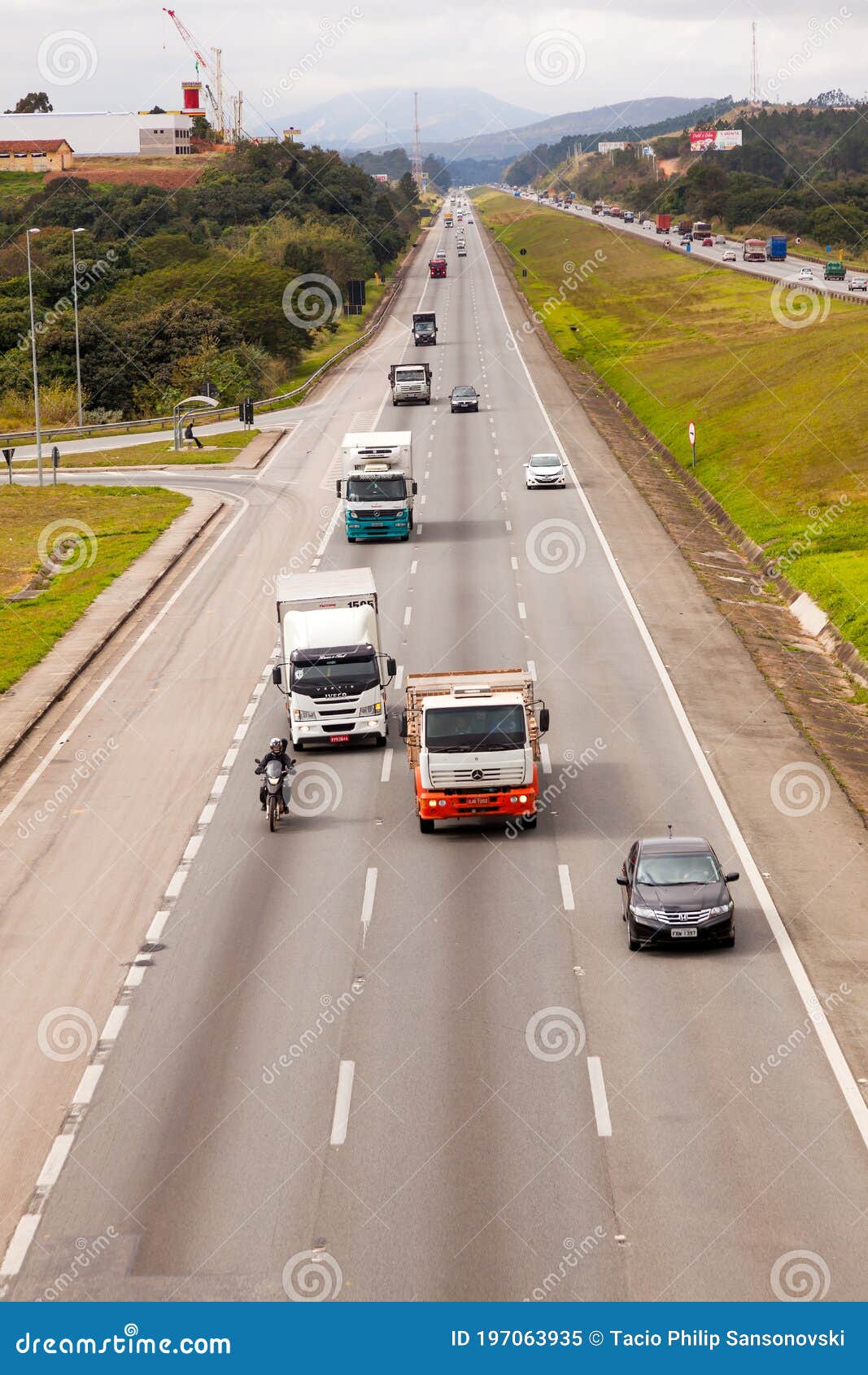 vehicles on br-374 highway with headlights on during the daylight obeying the new brazilian