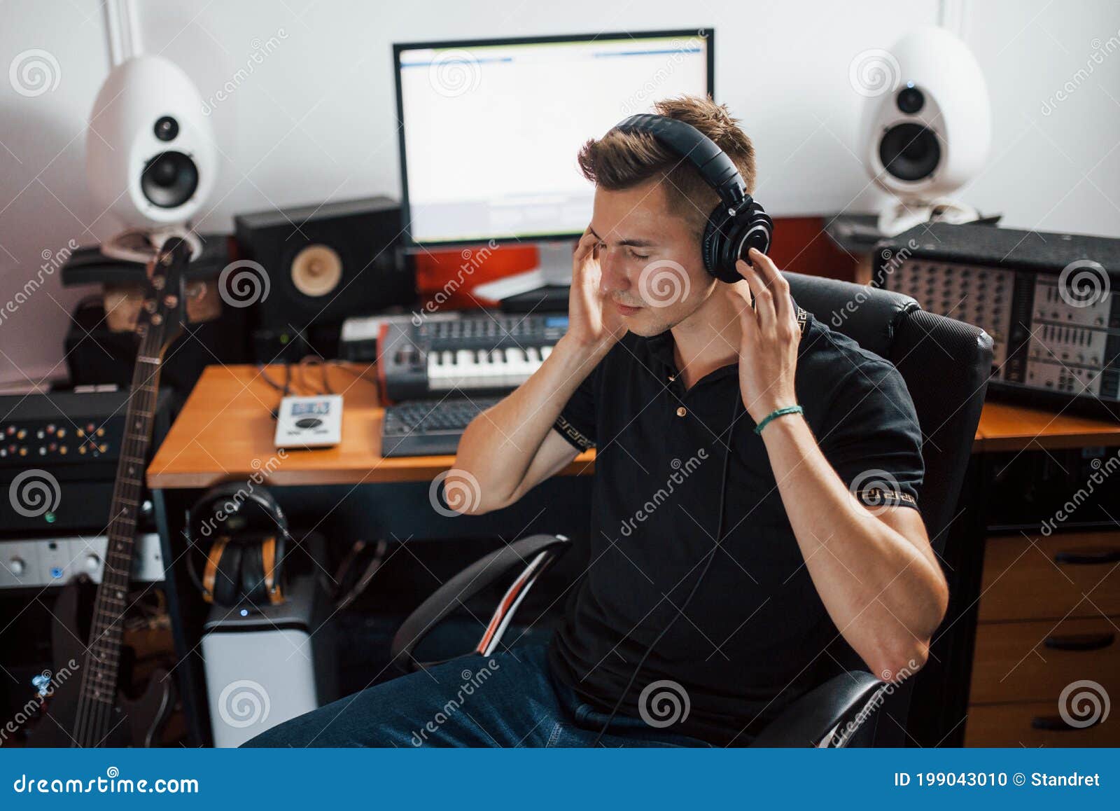 satisfied with audio quality. sound engineer in headphones working and mixing music indoors in the studio