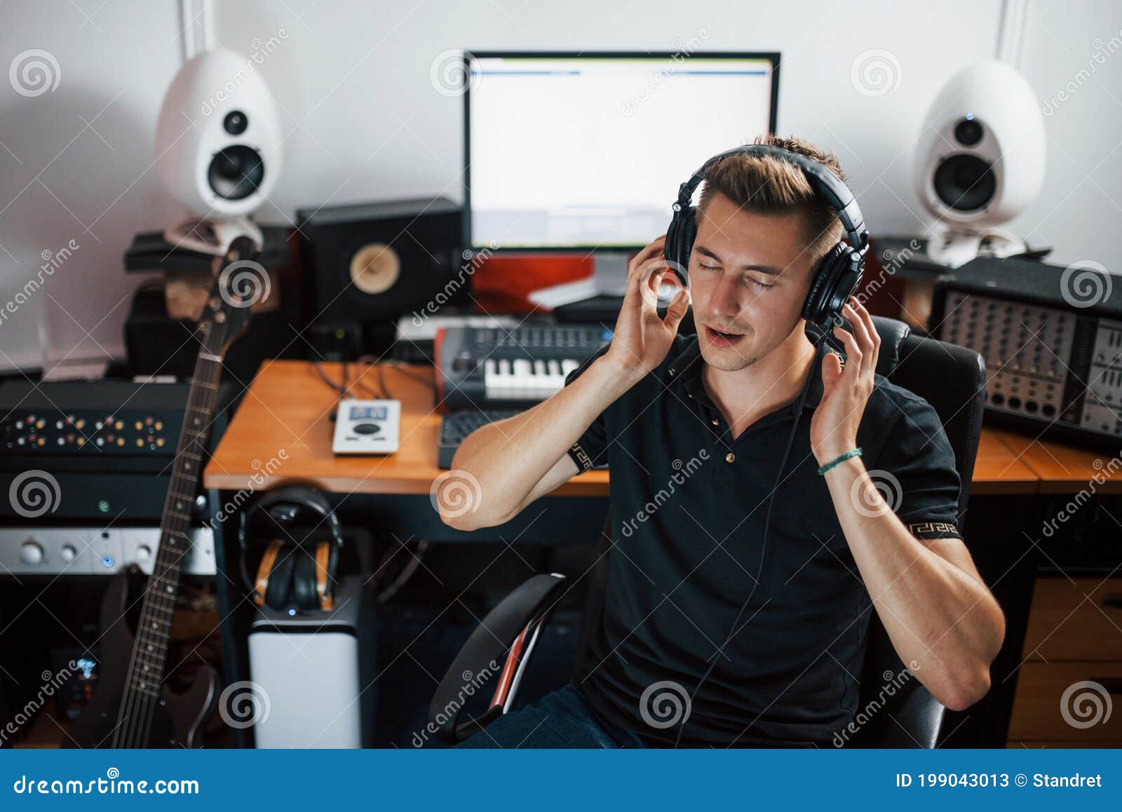 satisfied with audio quality. sound engineer in headphones working and mixing music indoors in the studio