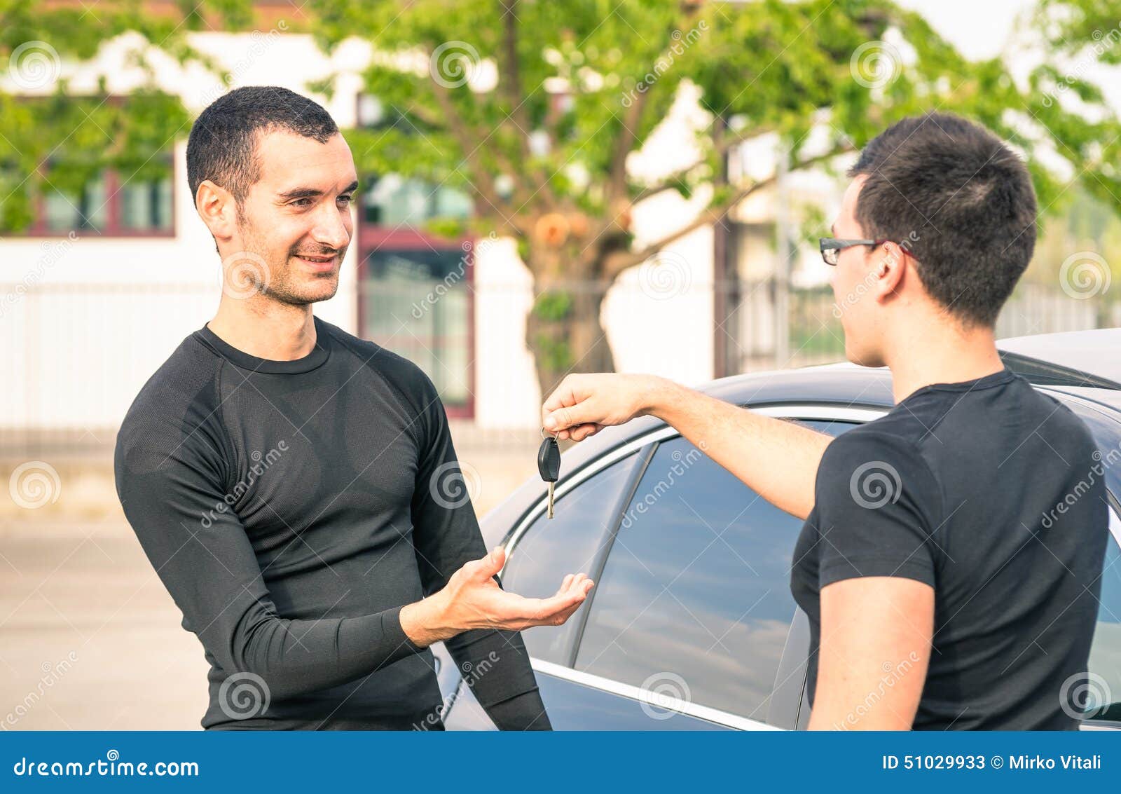satisfied buyer man receiving car keys after second hand sale