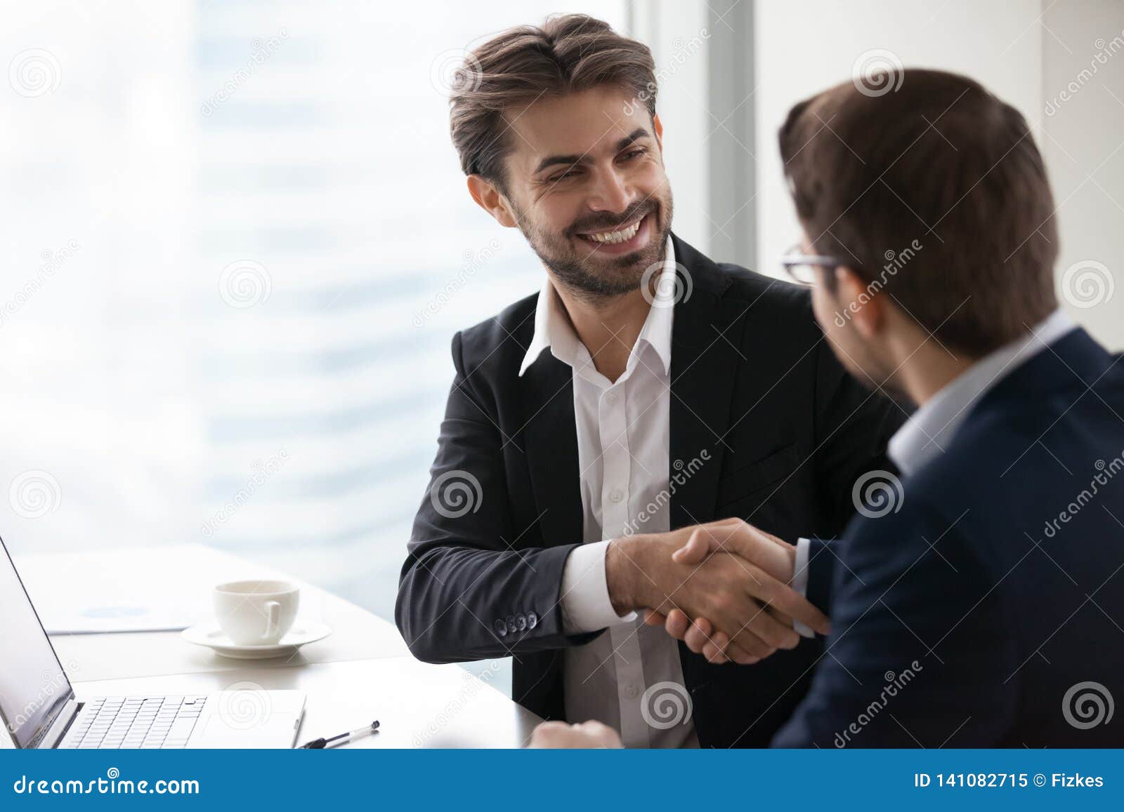 satisfied happy businessman in suit handshake business partner making deal