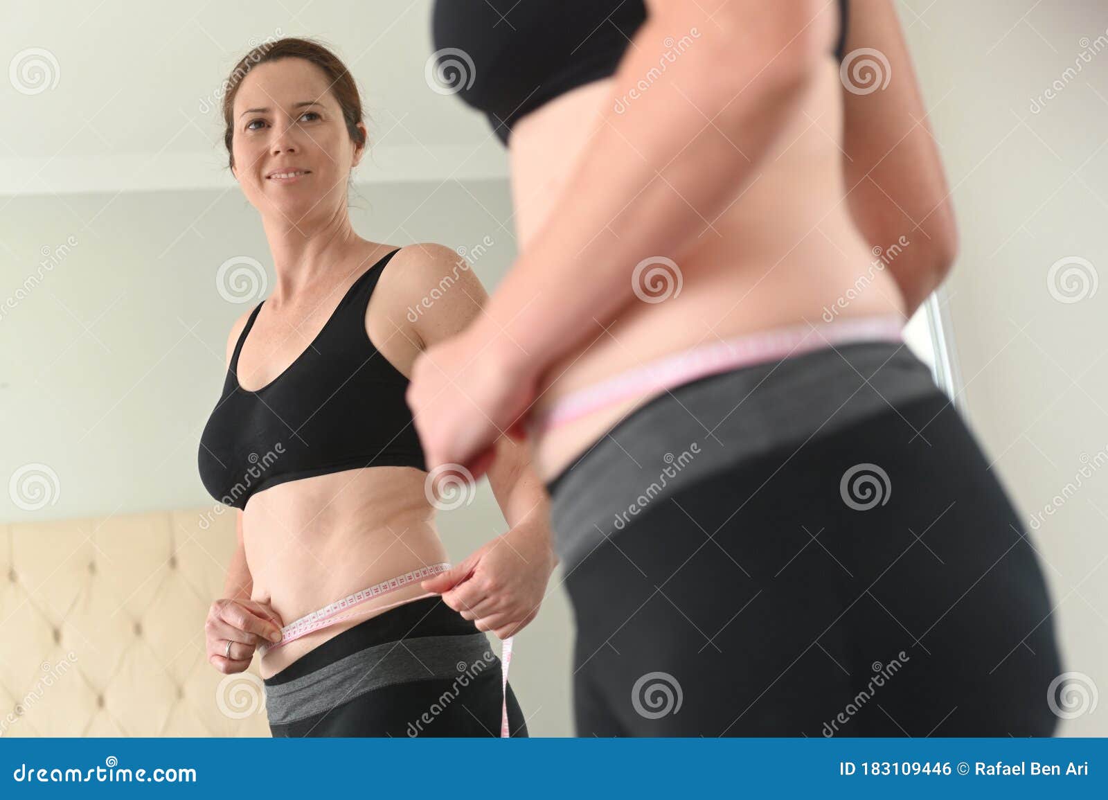 satisfy adult woman measuring waist circumference