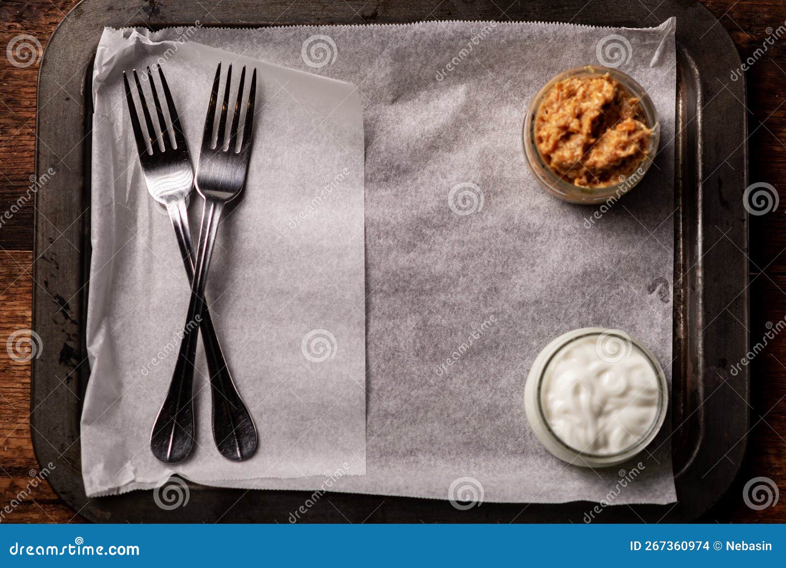 sauces in plates and forks on an empty paper-lined tray. serving start. place for text