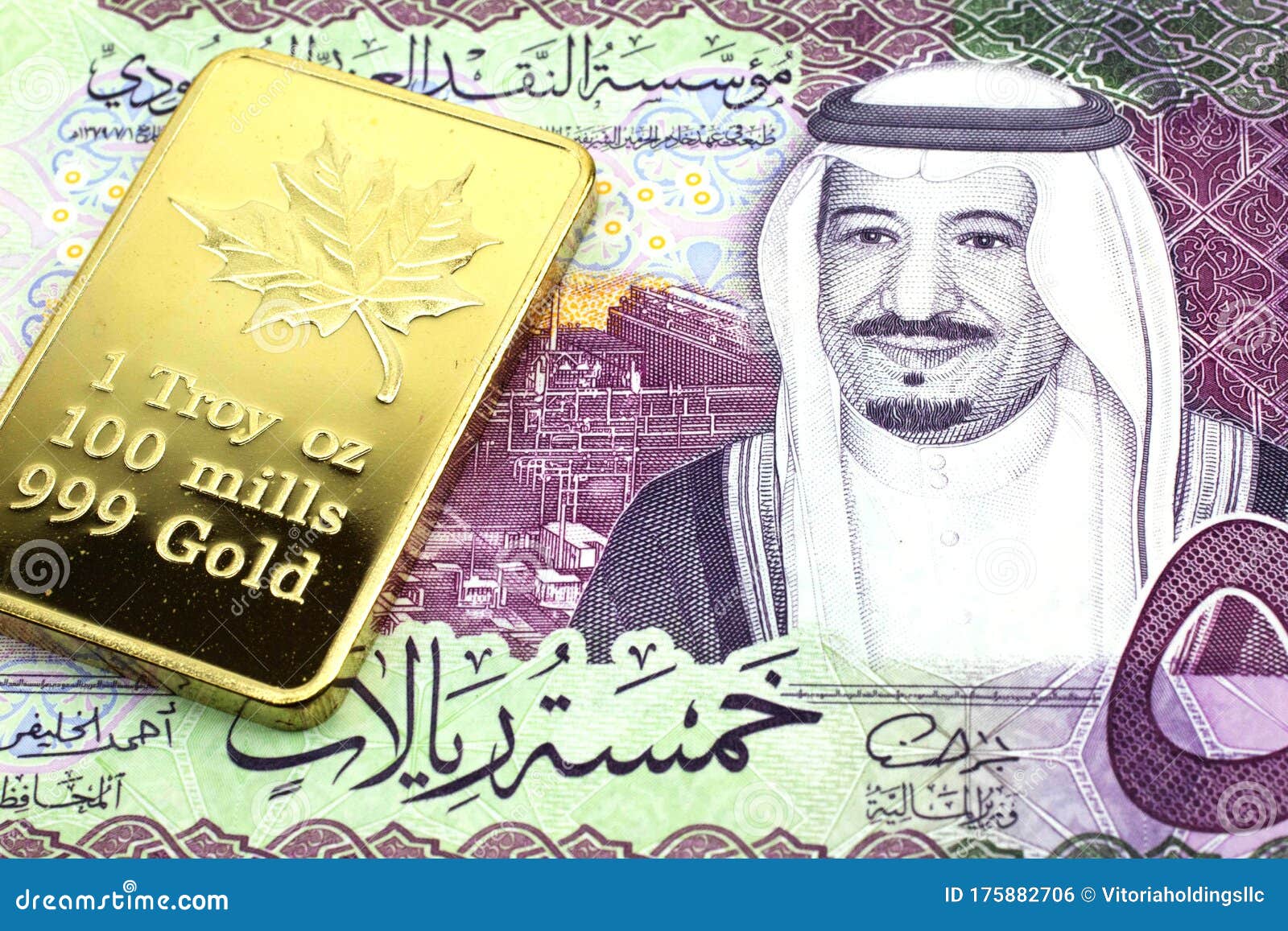 a saudi arabian riyal note with a gold bar in macro