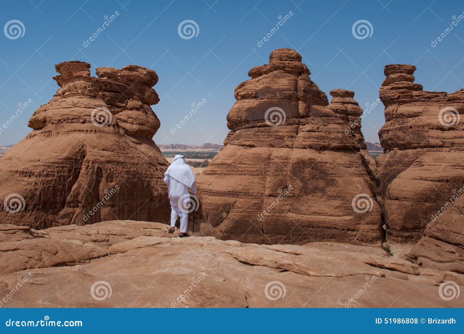 saudian walking on top of rock formations, saudi arabia