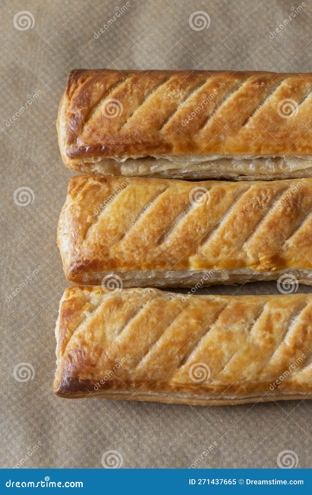 sausage rolls cooked on brown greaseproof baking paper. traditional british food