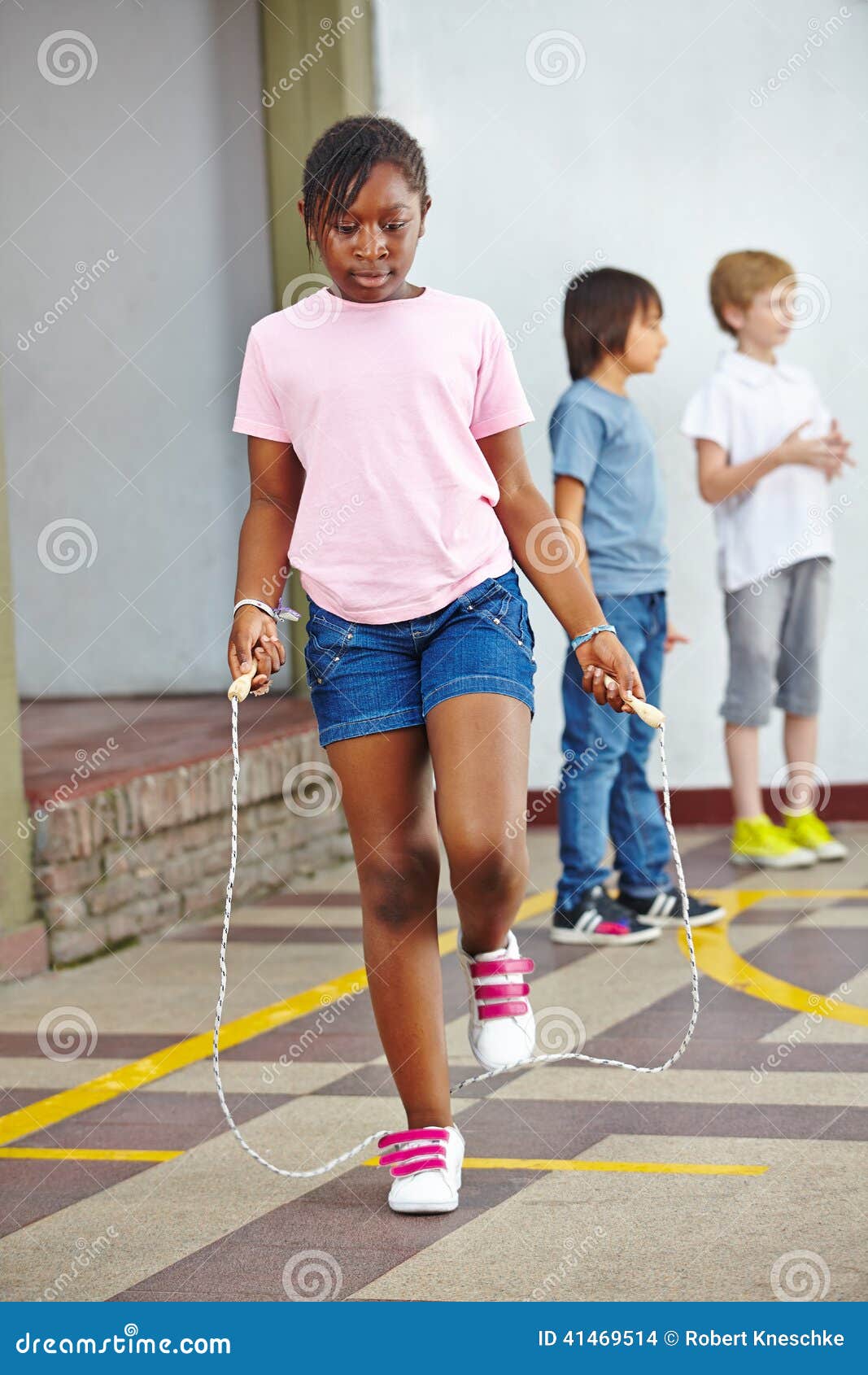 Enfants Jouant Le Jeu Sautant De Corde à Sauter Image stock