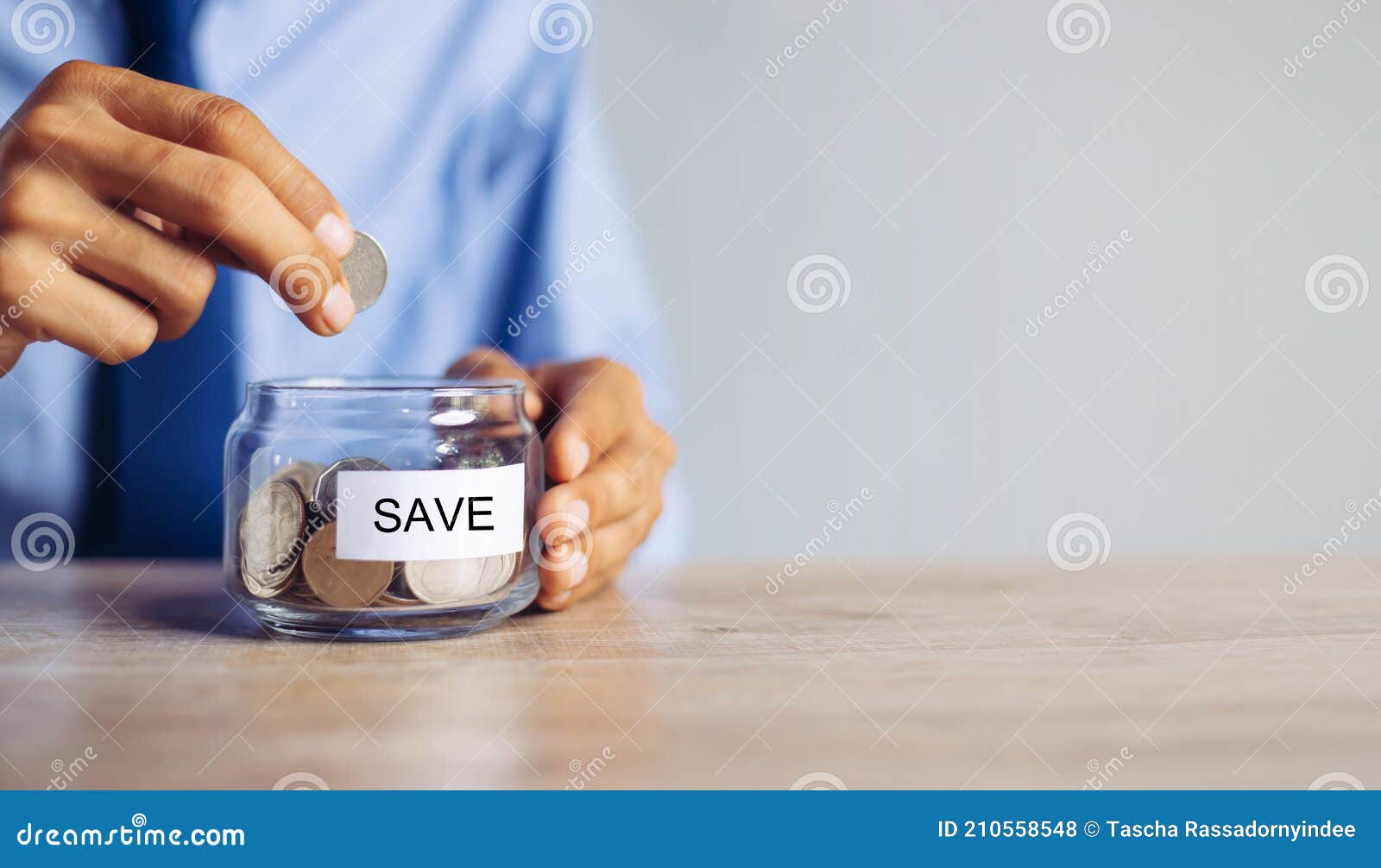 saving money concept preset by male hand putting money coin
