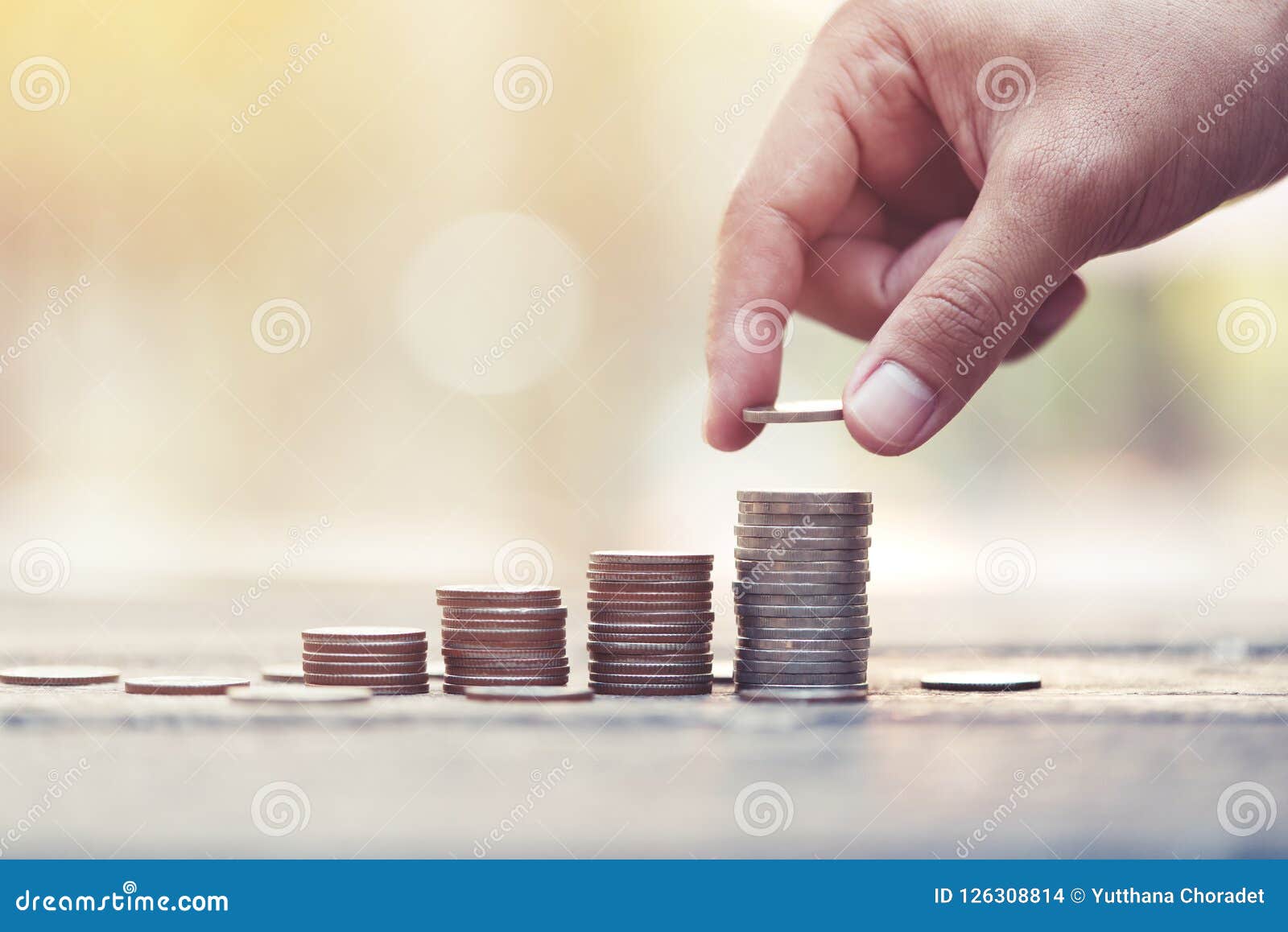 saving money concept. preset by male hand putting money coin stack.