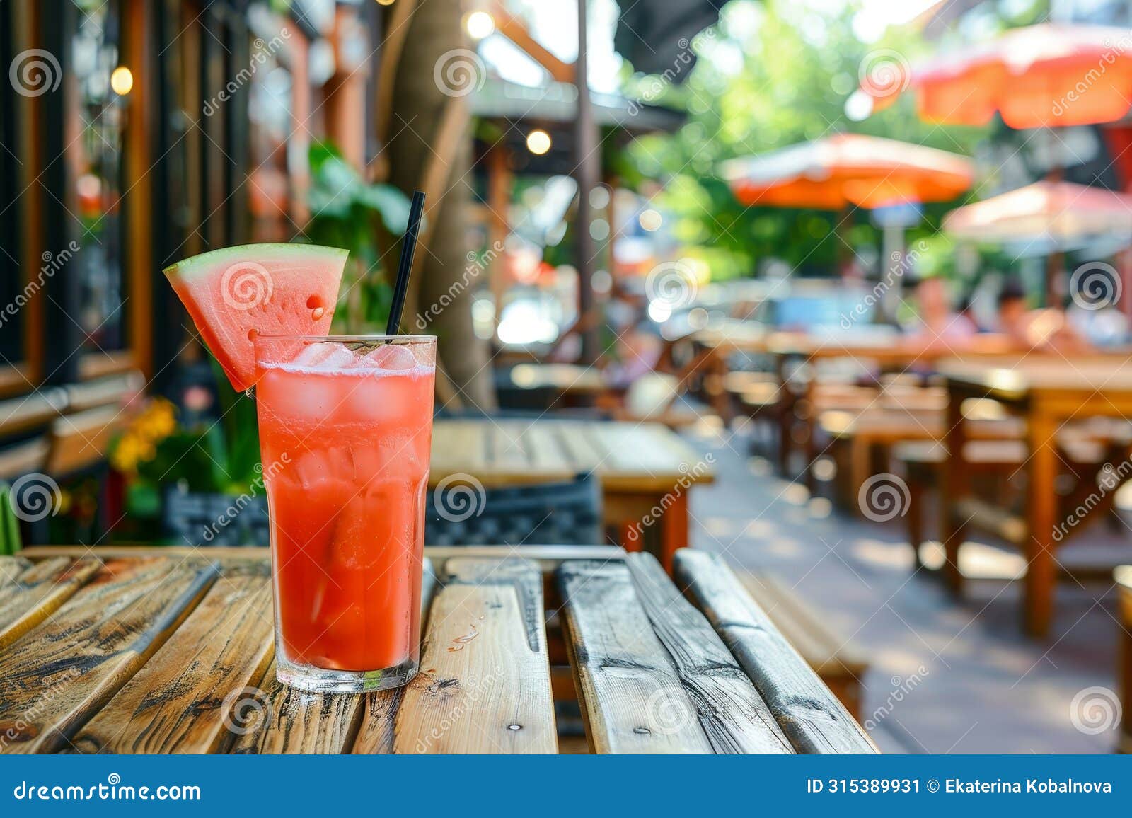 savor a delightful watermelon cocktail in a glass on a rustic wooden table at a quaint street cafe