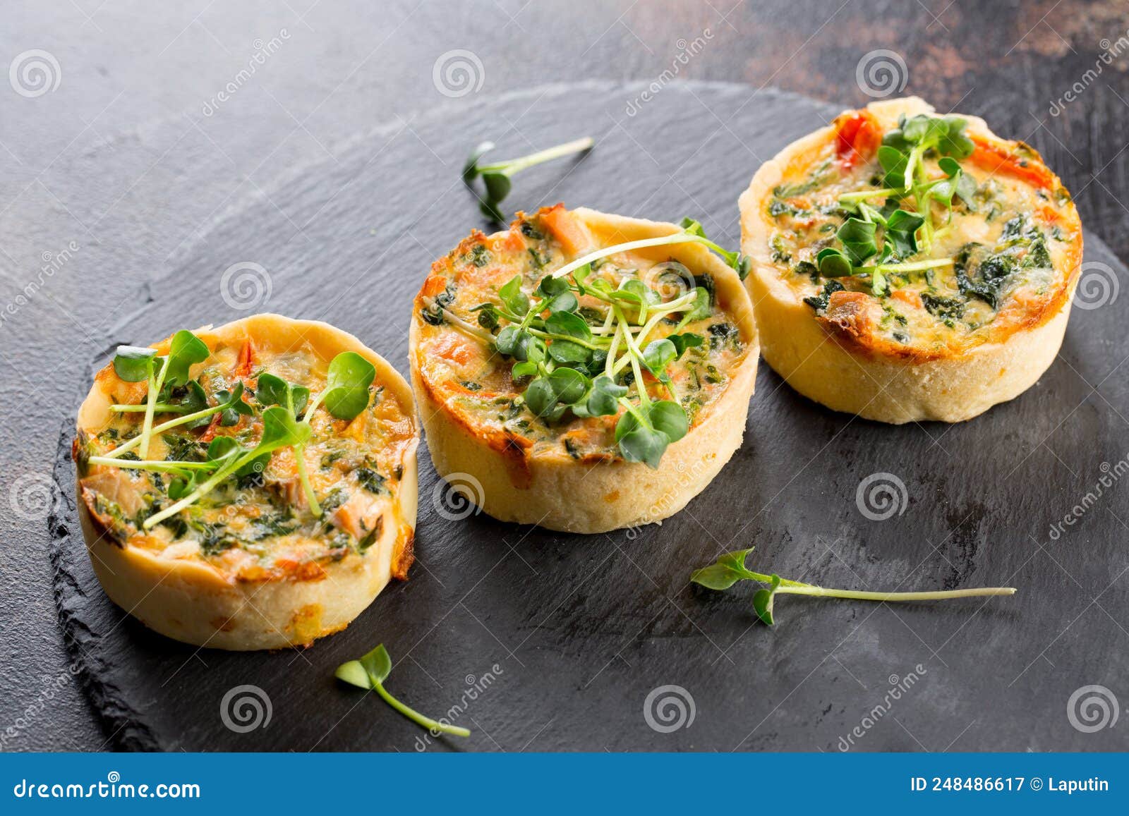 Savoury Mini Quiches with Custard and Watercress on a Black Round ...