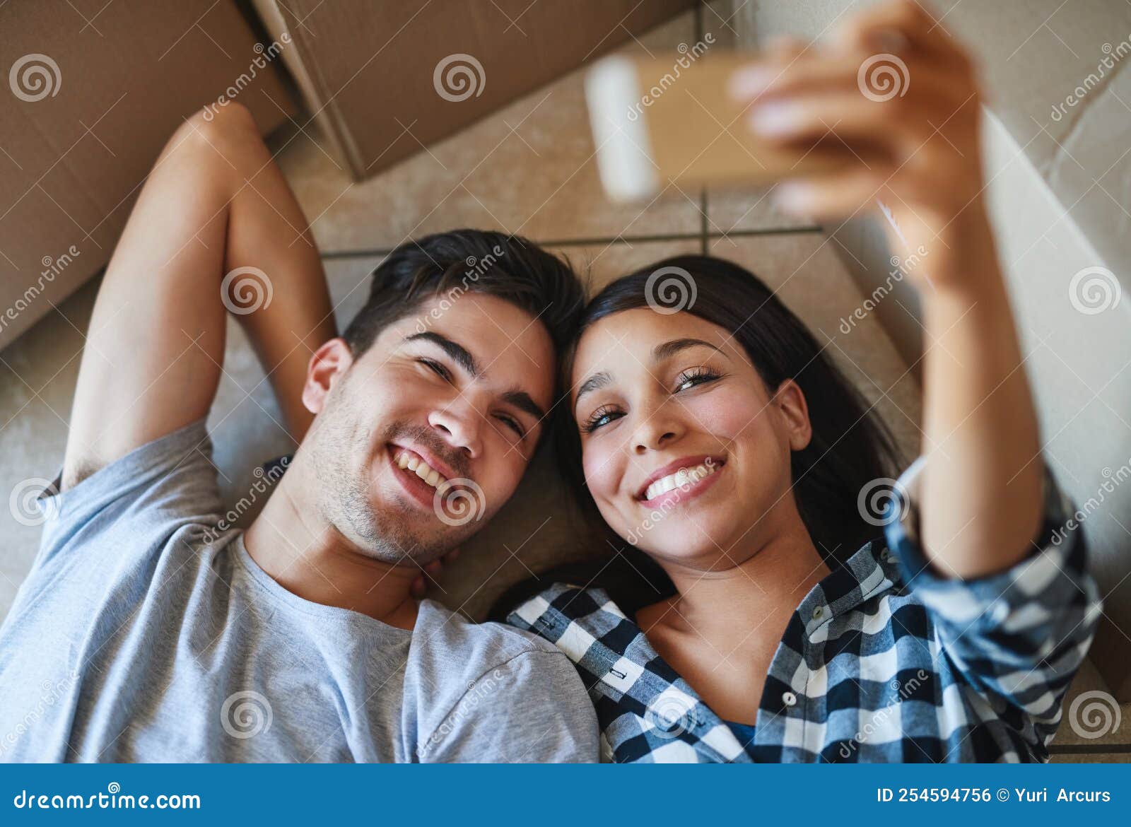 Say Cheese. a Happy Young Couple Taking a Selfie while Lying on the
