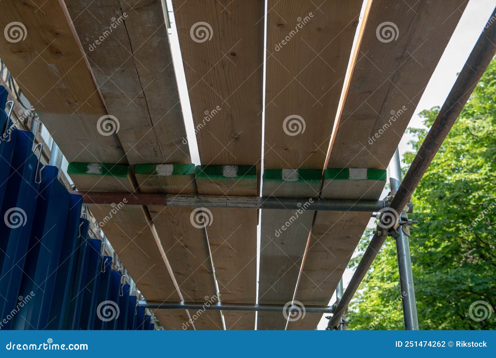 a scaffolding and wooden planks for protection and coverage on a construction site