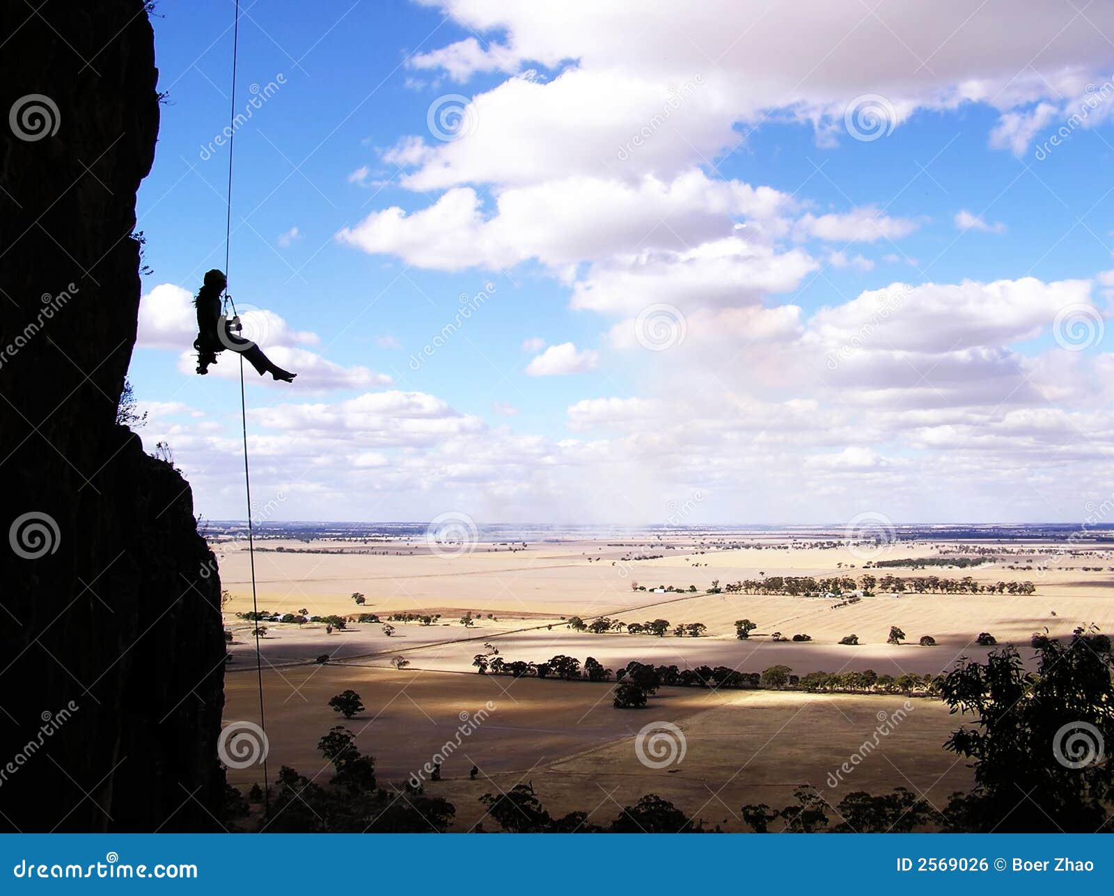 Scalatore di roccia che rappelling. Dopo con successo la scalata alla parte superiore, uno scalatore di roccia che abseiling fuori dal Mt. Arapiles, Australia.