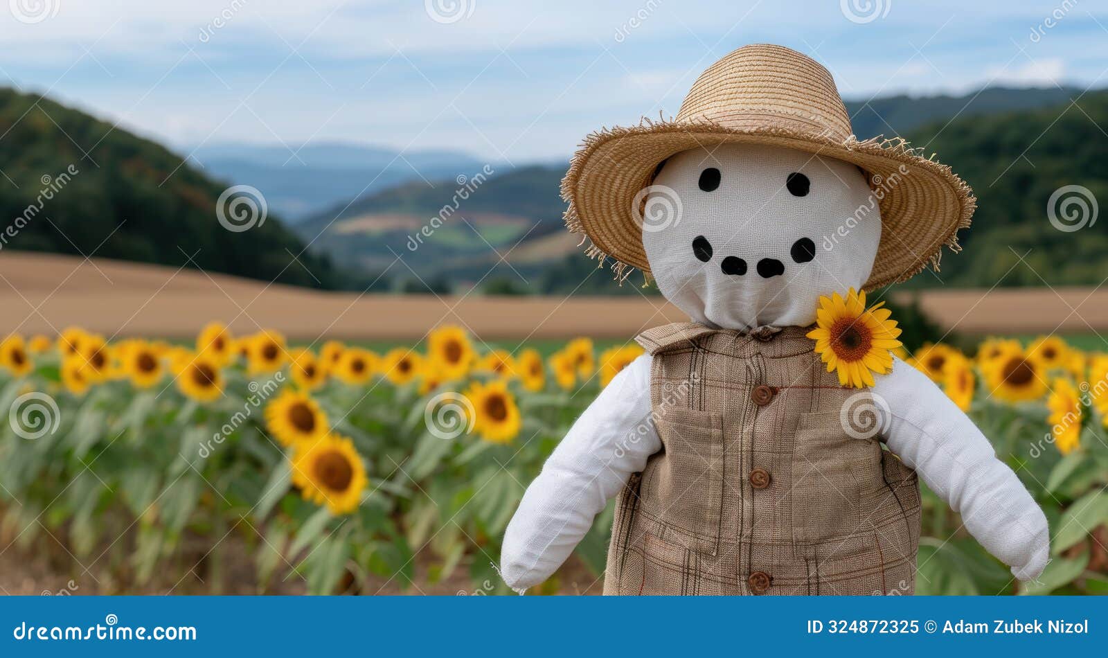 scarecrow in sunflower field with mountains in background