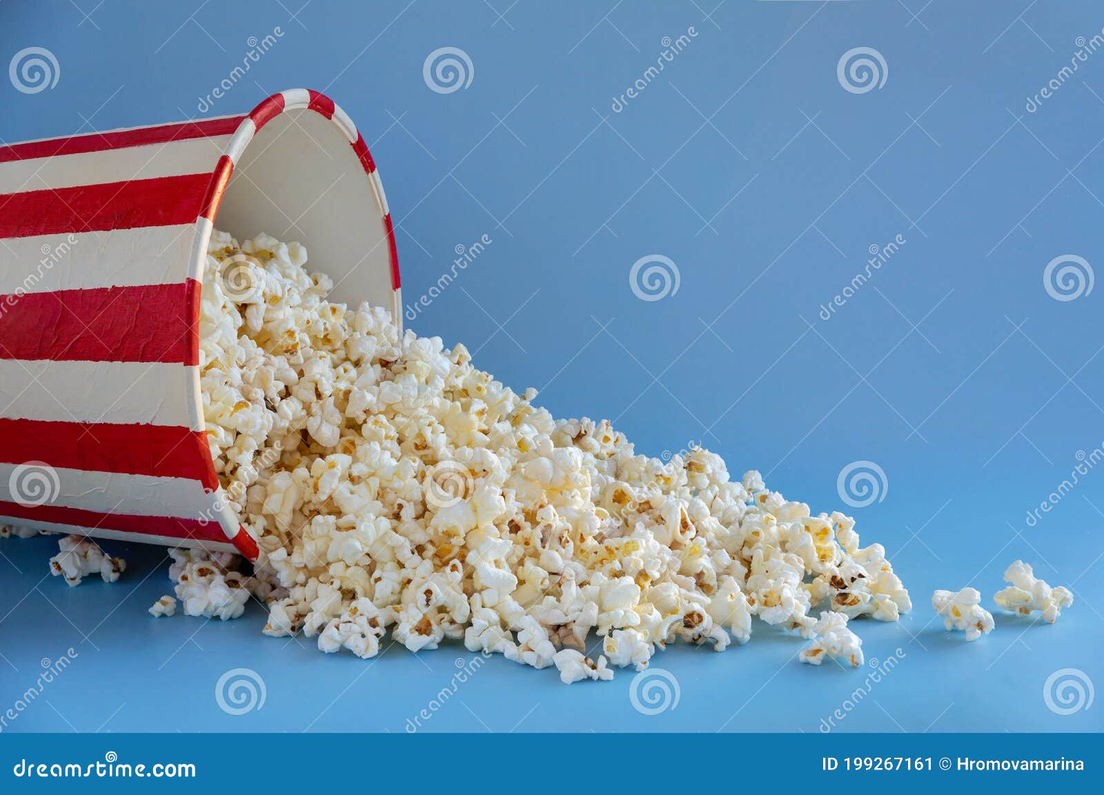 Scattered Large Bucket of Popcorn on a Blue Background Stock Image