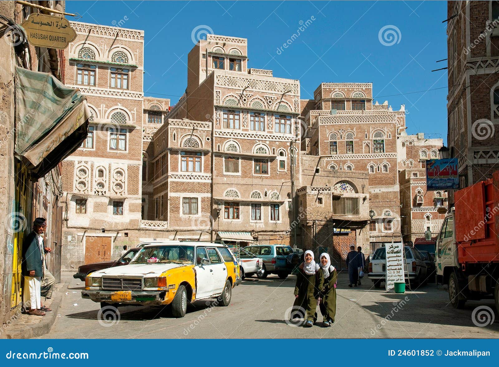 Scena della via del Yemen della città di Sanaa con la gente ed il tassì. Sanaa, capitale del Yemen, è conosciuto per esso è stile dell'architettura tradizionale unico. http://en.wikipedia.org/wiki/Sana'a
