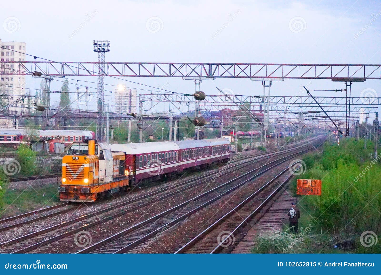 scene of orange locomotive and red train in carpati station, bucharest, cfr