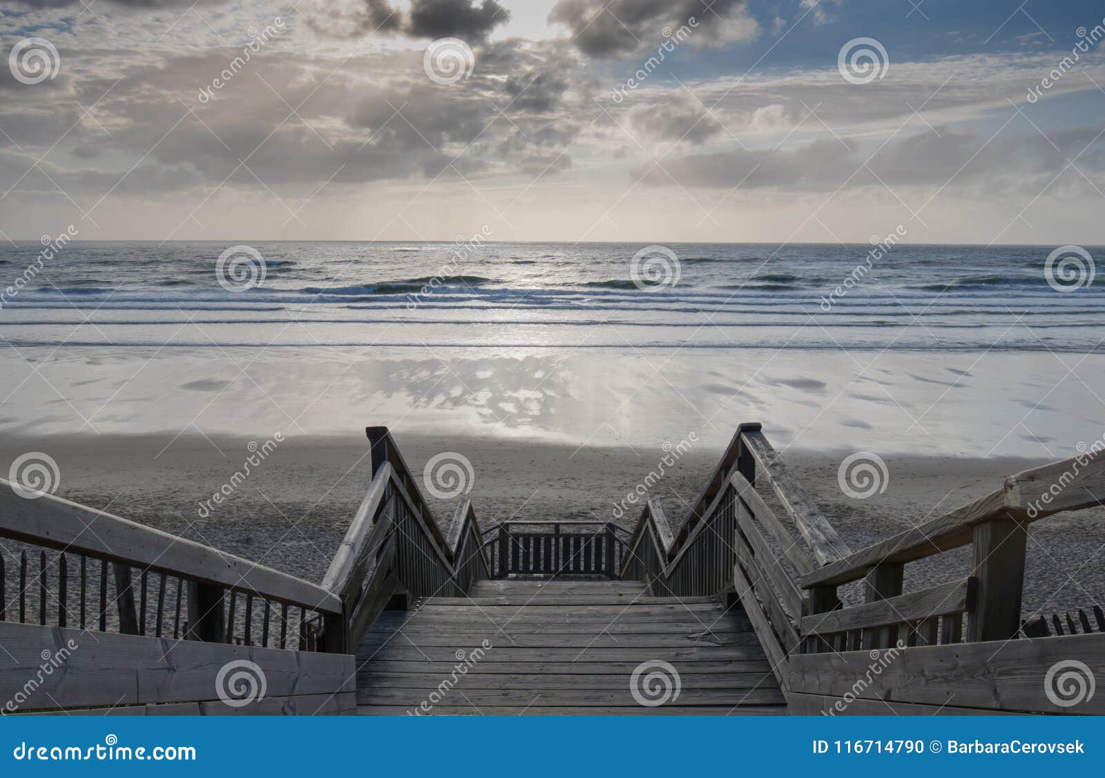 scenic biscarrosse beach in sunset with clouds and wooden footpath stairs, france