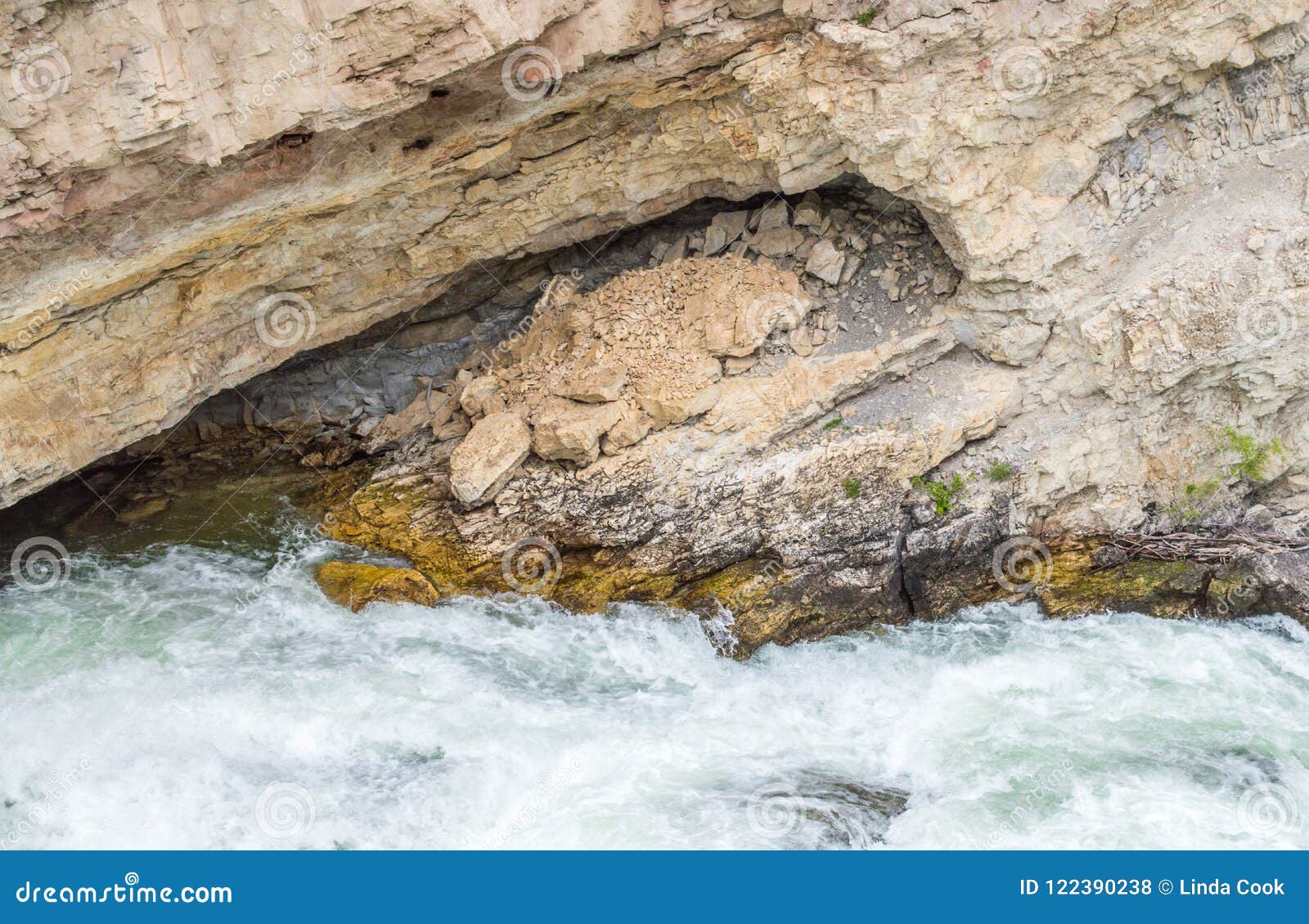 boulder river rushing through a sea grotto and jagged rock wall in montana