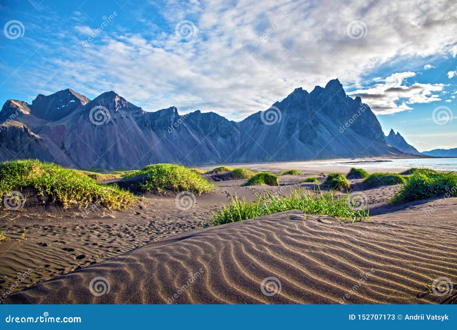 scenic landscape with most breathtaking mountains vestrahorn on the stokksnes peninsula and cozy lagoon with green grass on the