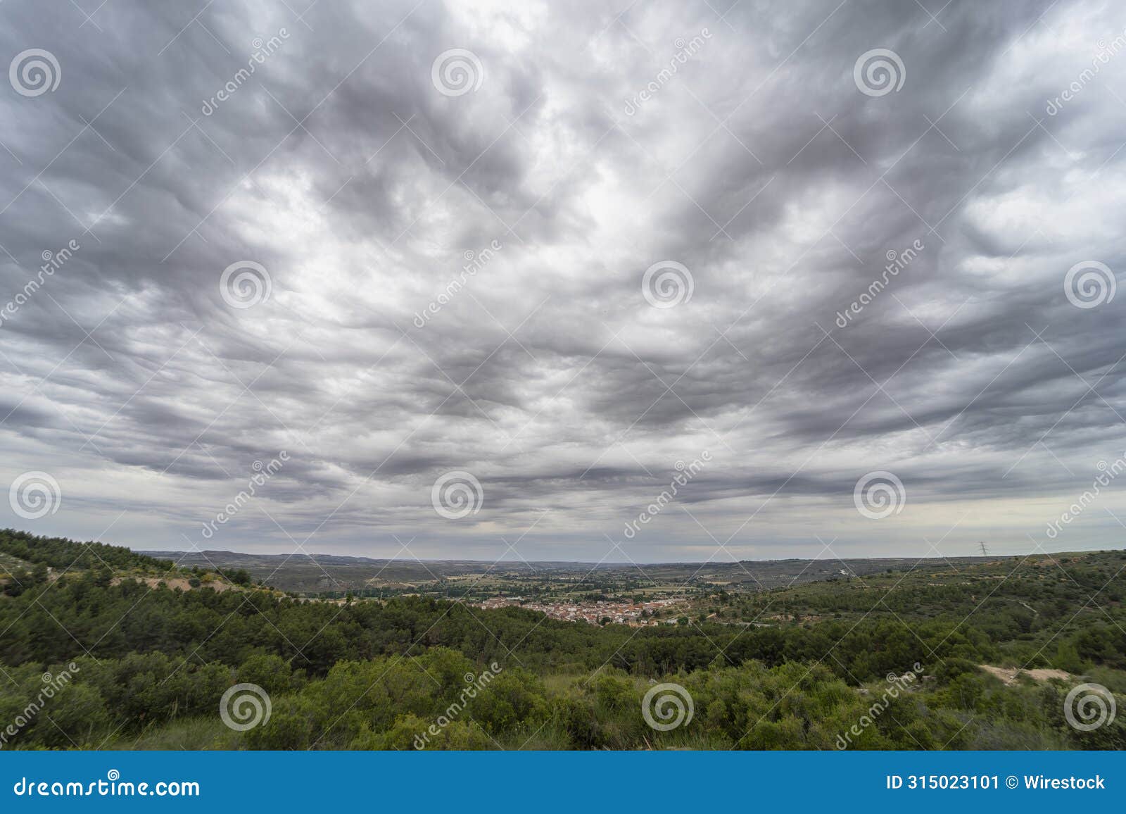 scenic tajuna valley under a dark gray sky, dotted with asperitas clouds