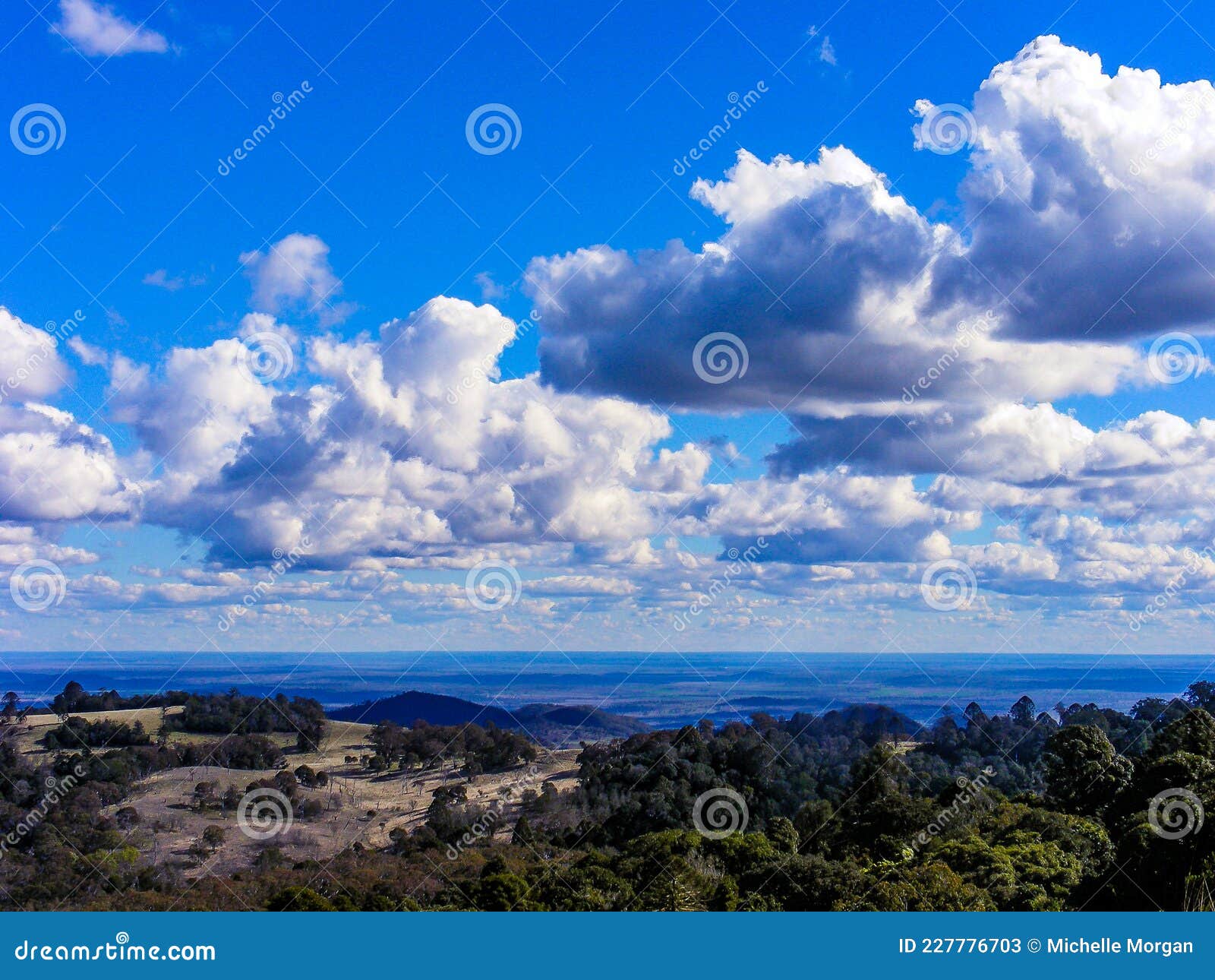 scenic view with green hills and blue sky with white fluffy clouds 2.