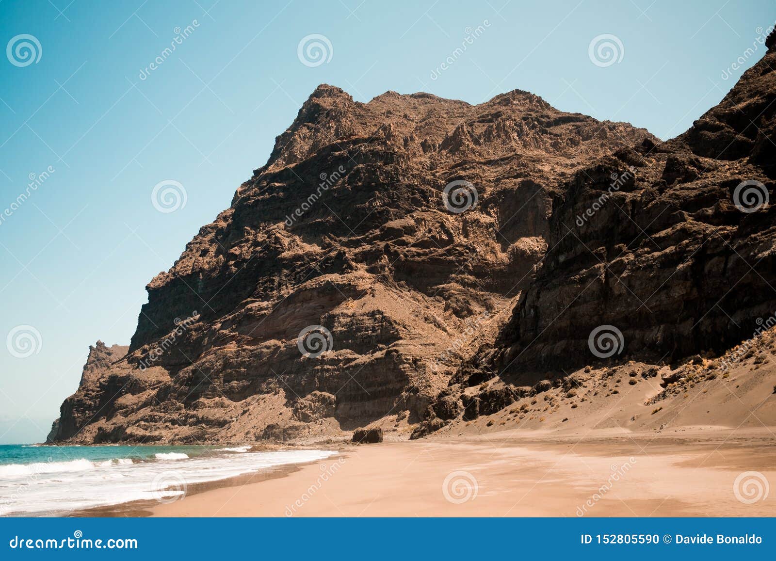 scenic view of gui gui beach in gran canaria island in spain with spectacular mountains landscape and clear blue sky and sandy
