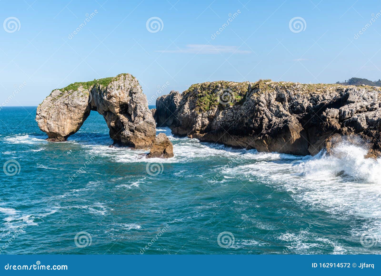 scenic view of sea against blue sky in rocky coast