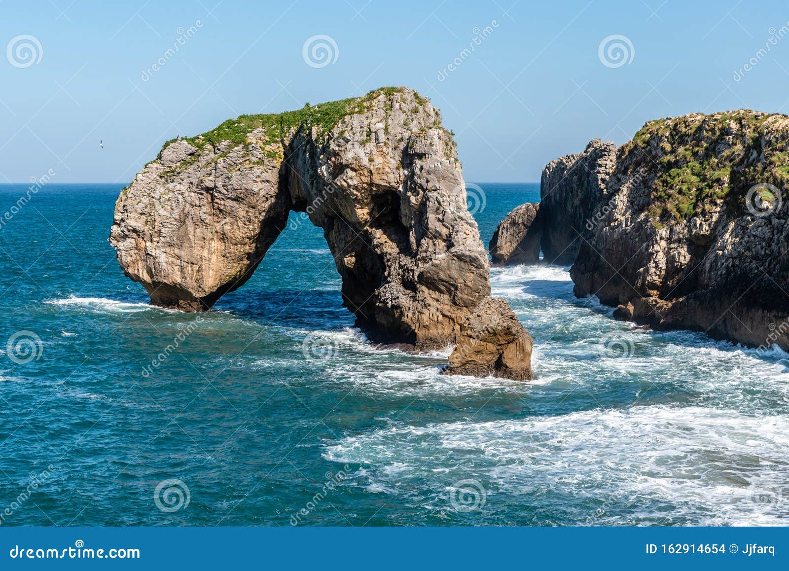 scenic view of sea against blue sky in rocky coast