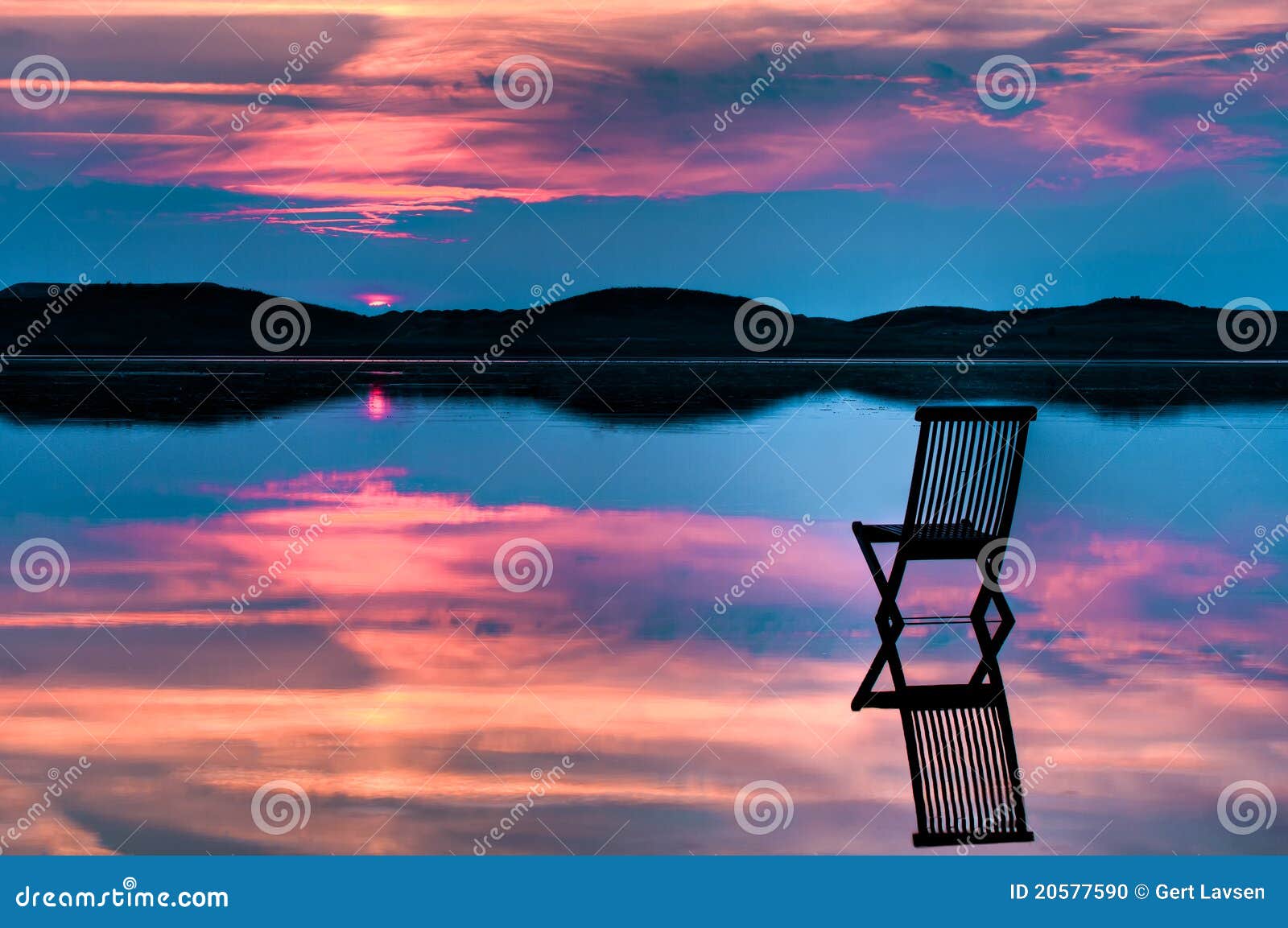 scenic view of sunset with chair in calm water