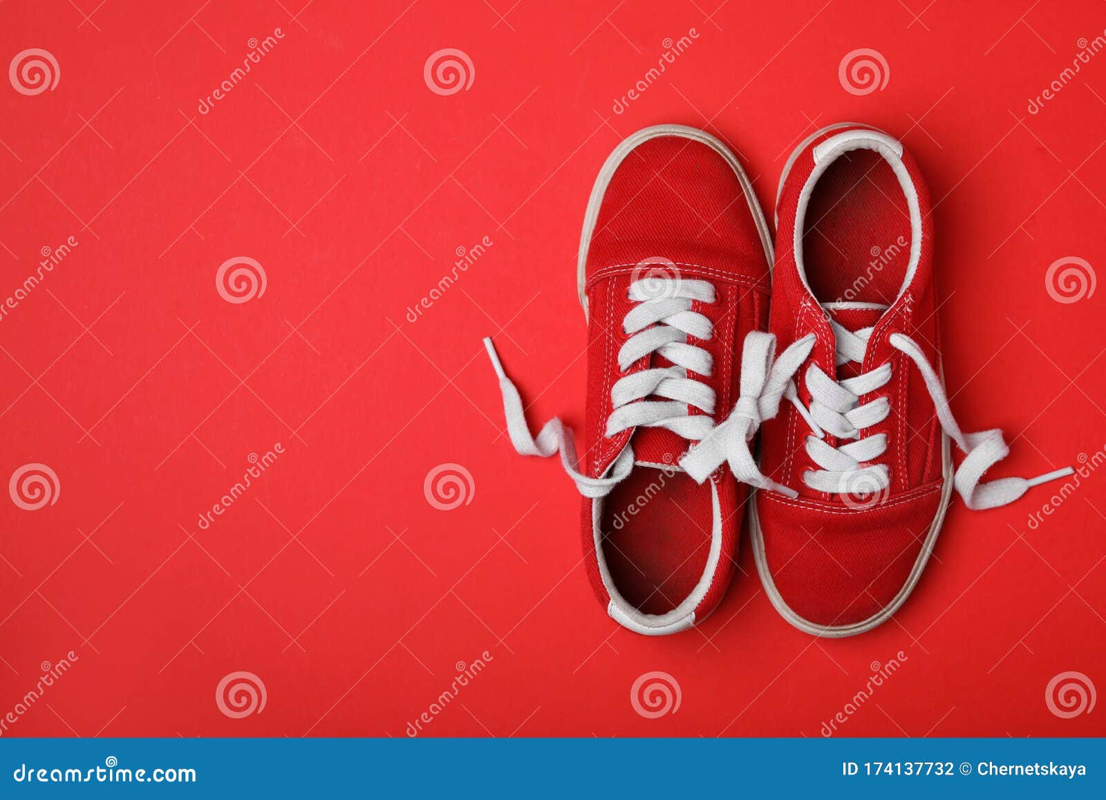 Schoenen Aan Elkaar Vastgebonden Op Een Rode Vlakke Ondergrond Met Ruimte Voor Tekst. Dag April Stock Foto - Image of