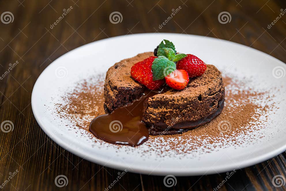 Schokoladenfondant-Lavakuchen Verziert Mit Erdbeeren Und Kakaopulver ...